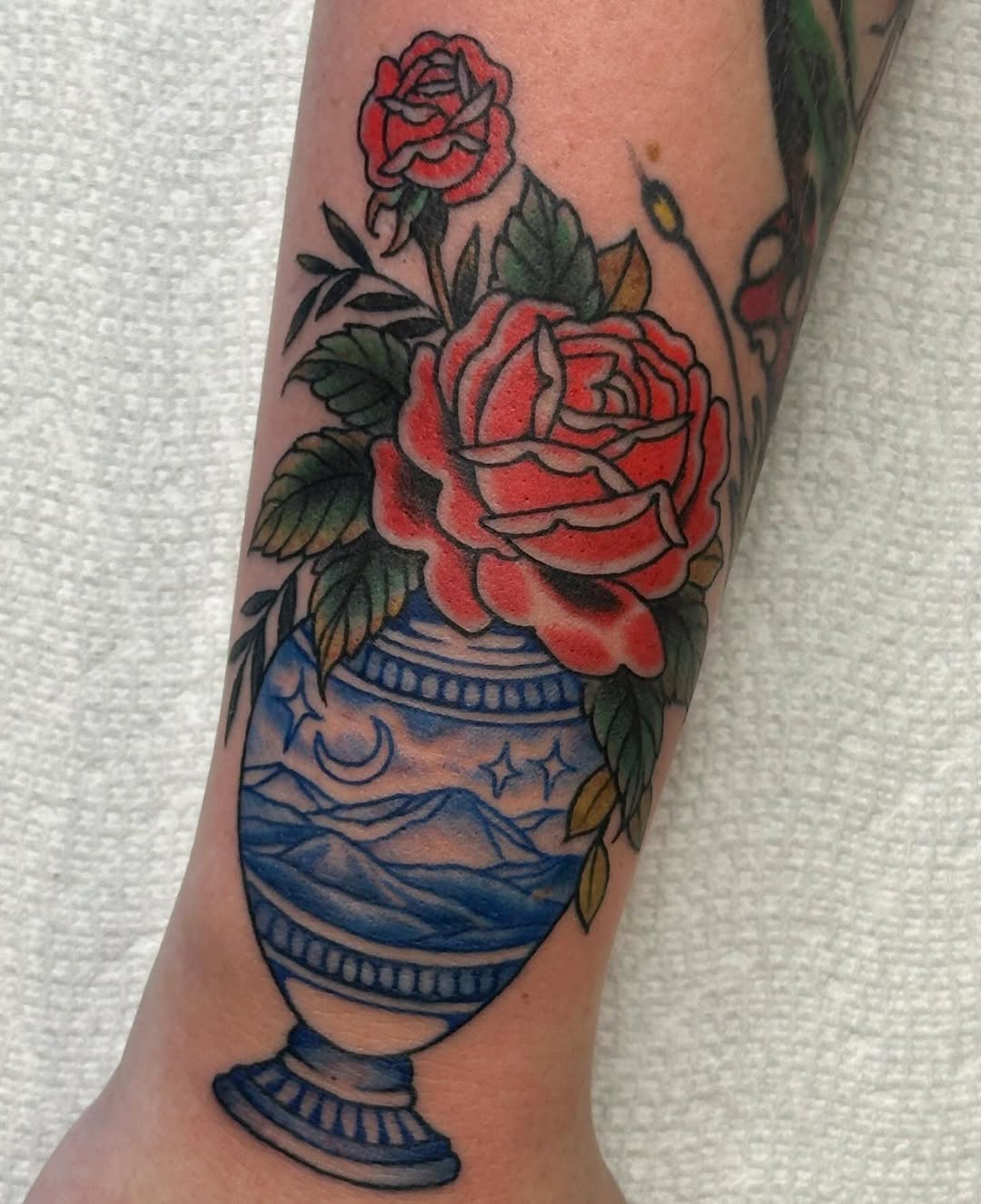 Roses in a vase with landscape neo-traditional tattoo on the forearm by 🦎Langley Osborn Tattoos🦎, Maryville, Tennessee