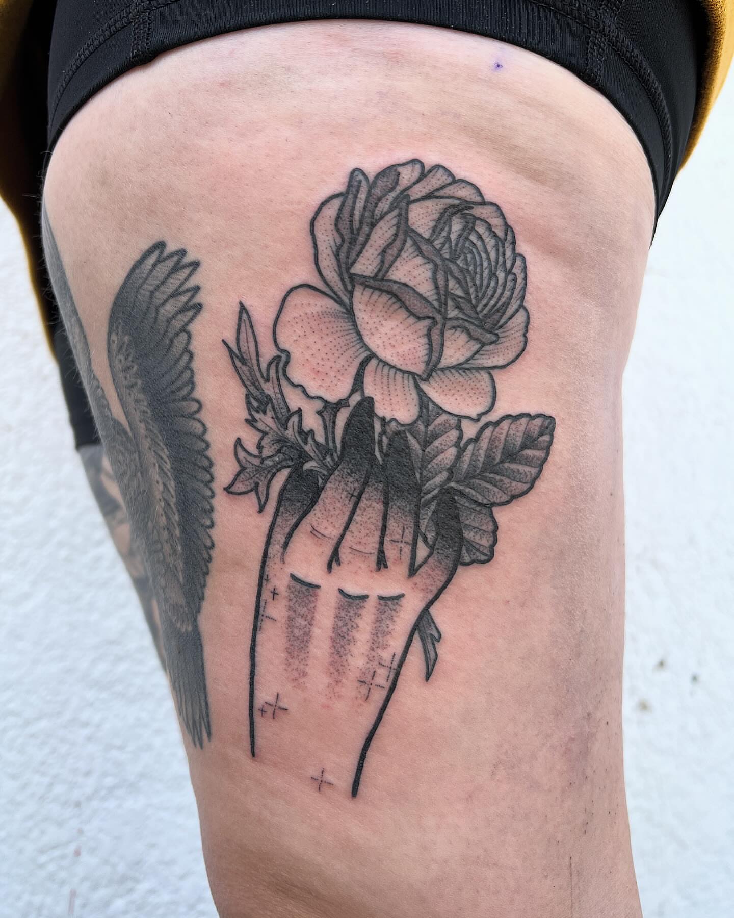Rose and hand dotwork tattoo on the thigh by Daniel Patrick