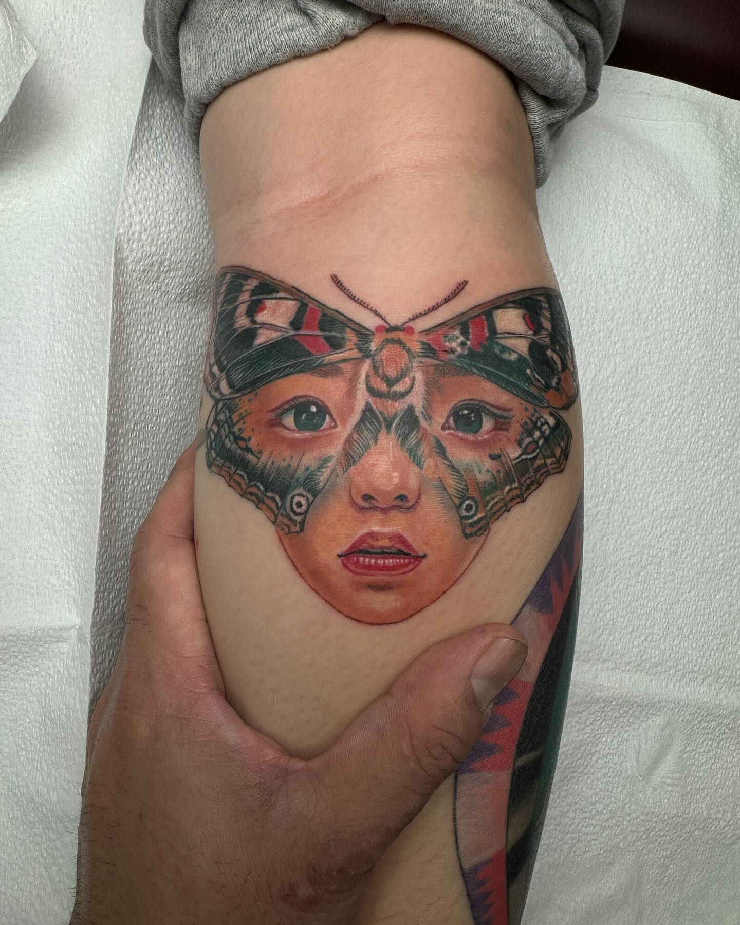 Woman's face with butterfly wings realism tattoo on the forearm by Vinny Holistic Ink