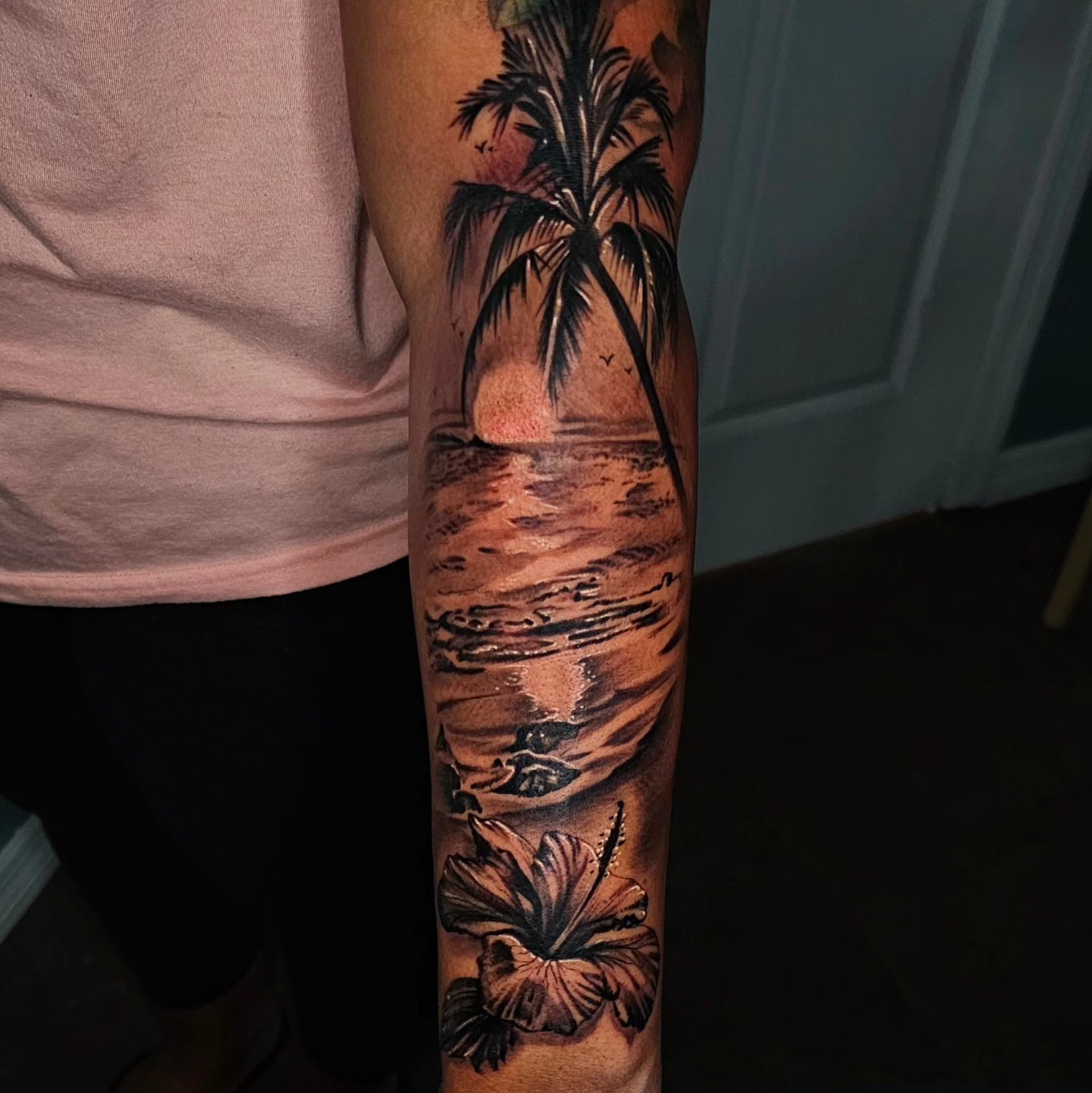 Beach sunset realism tattoo on the forearm by Christian Mulvey