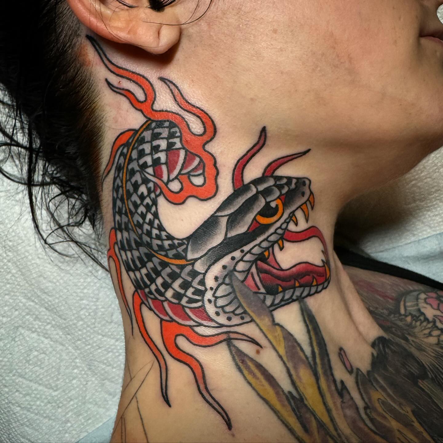 Snake American traditional tattoo on the neck by Ethan Bennett