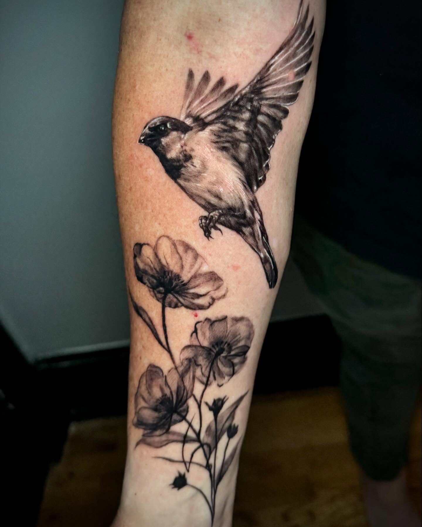 Sparrow and flowers realism tattoo on the forearm by Martina Zago