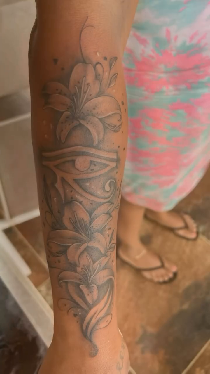 Egyptian eye with floral elements fine line tattoo on the upper arm by oxideTattoo, Morne-à-l'Eau