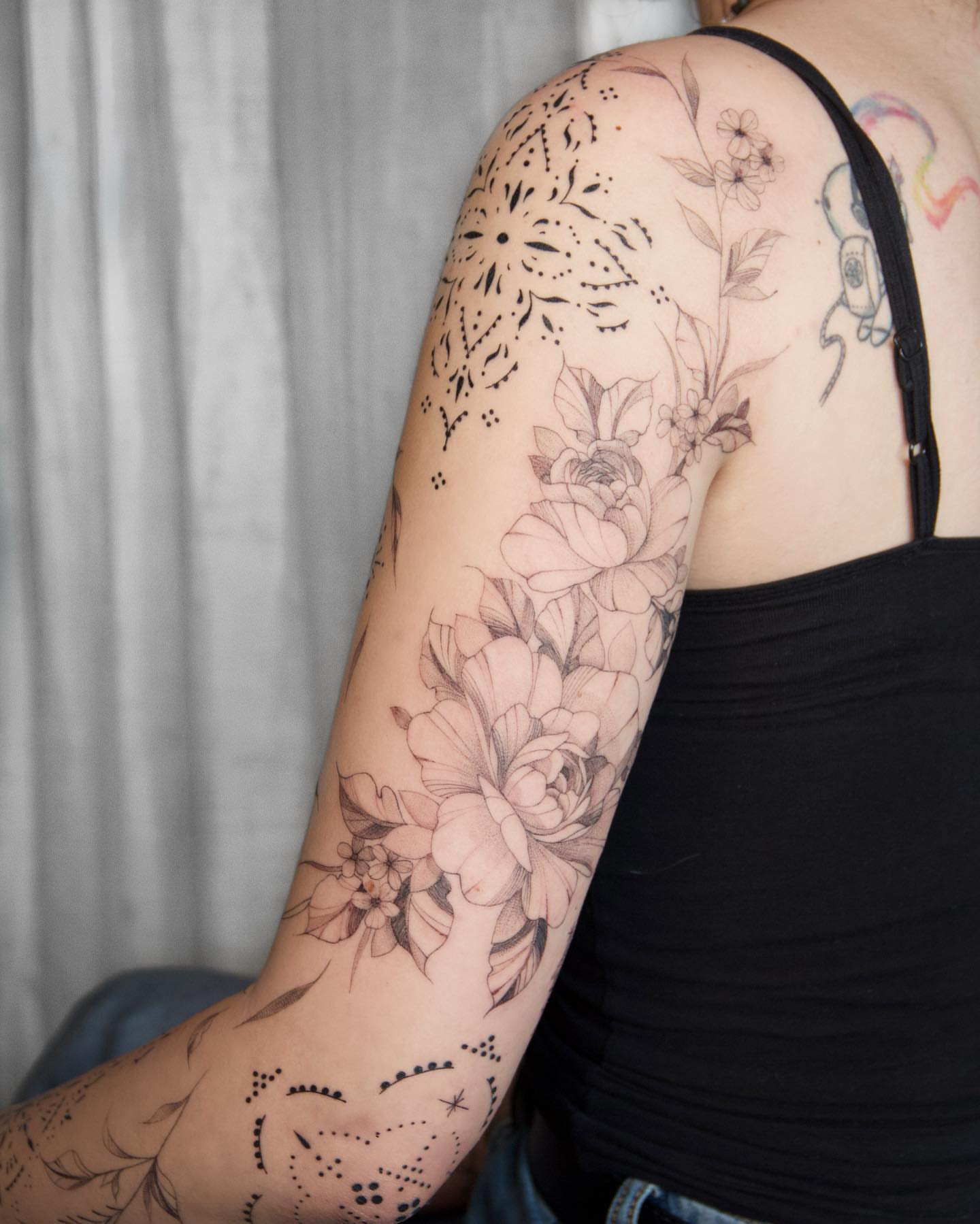 Floral bouquet dotwork tattoo on the upper arm by Liv
