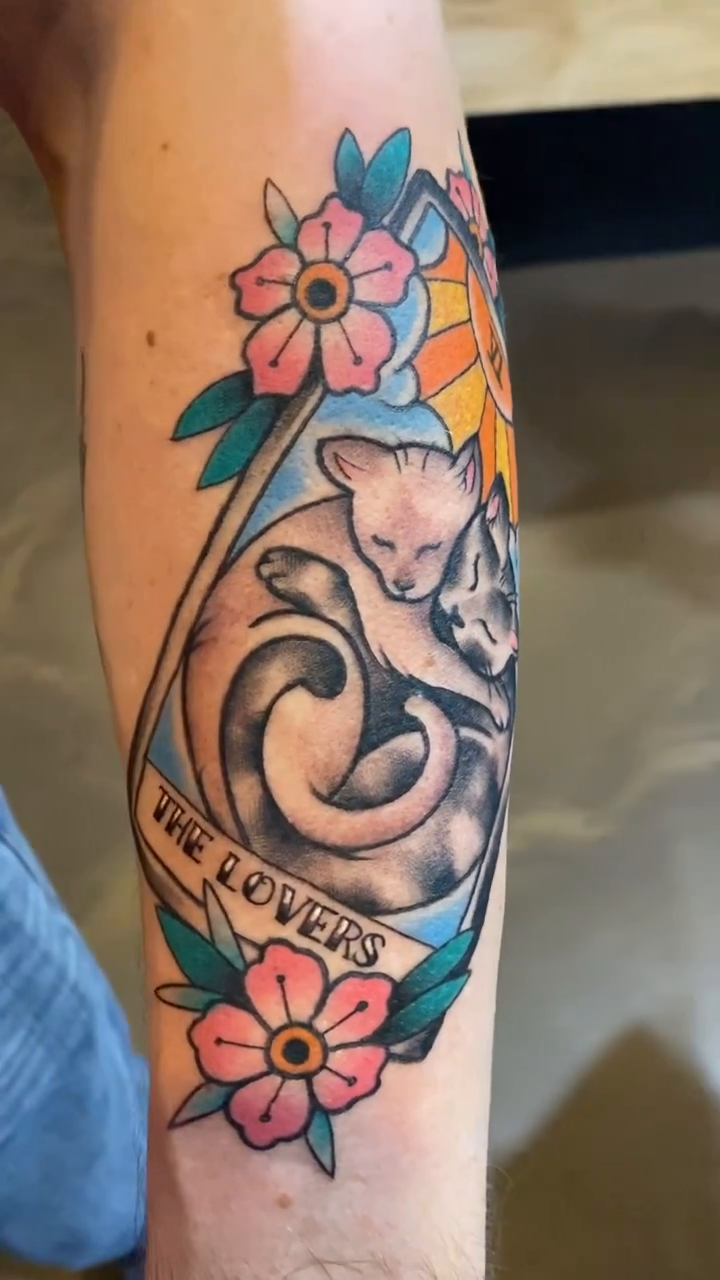 Two cats embracing neo-traditional tattoo on the forearm by Cody Wolfe