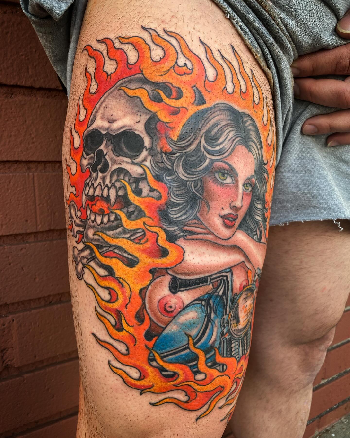 Flaming skull and woman American traditional tattoo on the thigh by Adam Warmerdam, Los Angeles, California