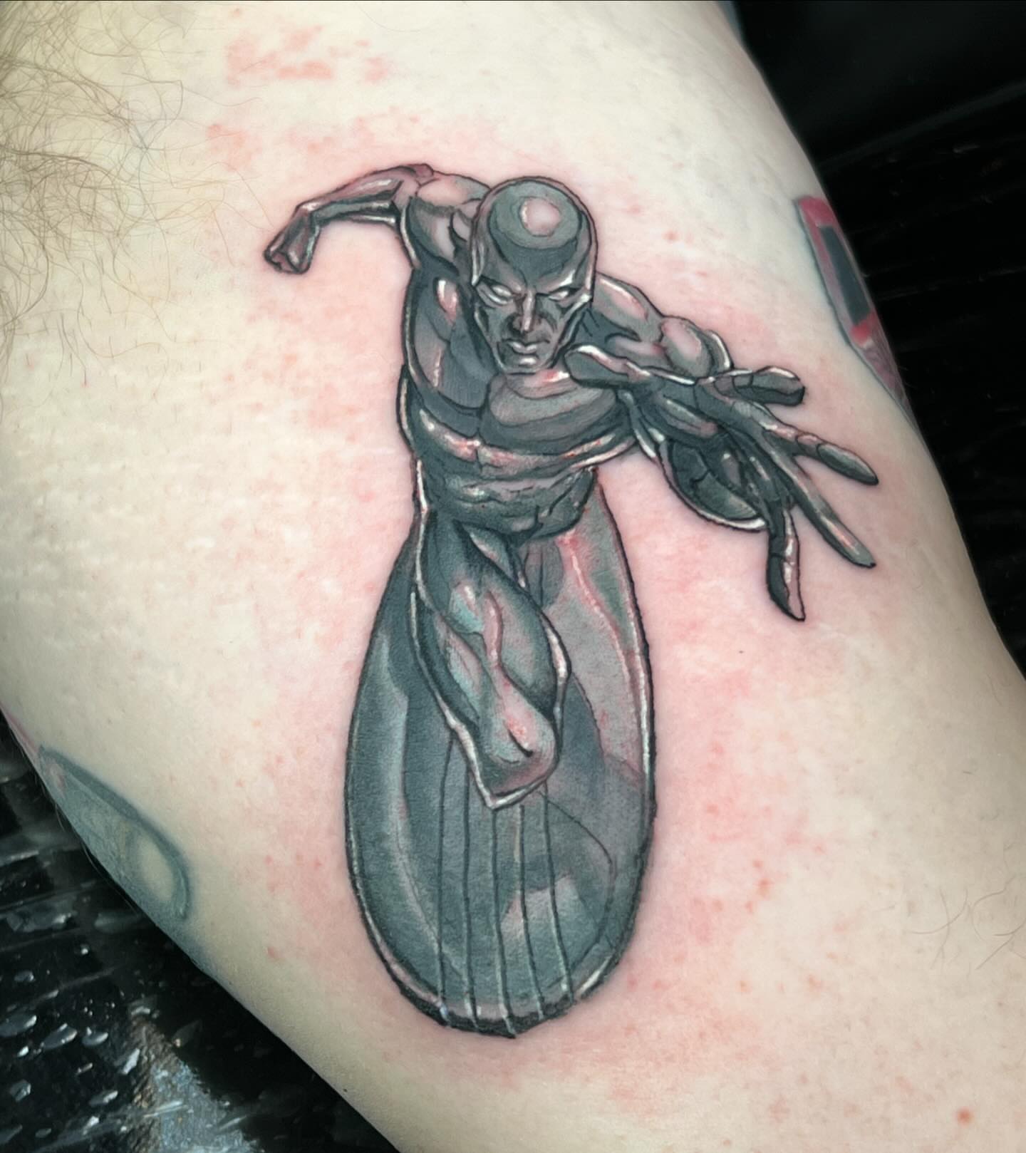 Silver superhero realism tattoo on the thigh by Josh Green
