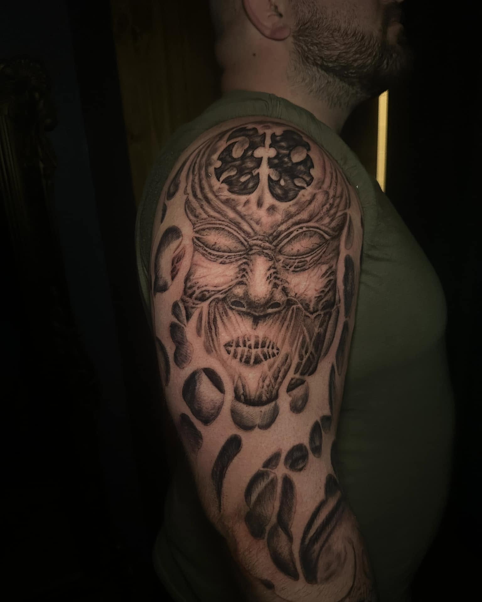 Mask dotwork tattoo on the upper arm by Jacob Martin, Toledo, Ohio