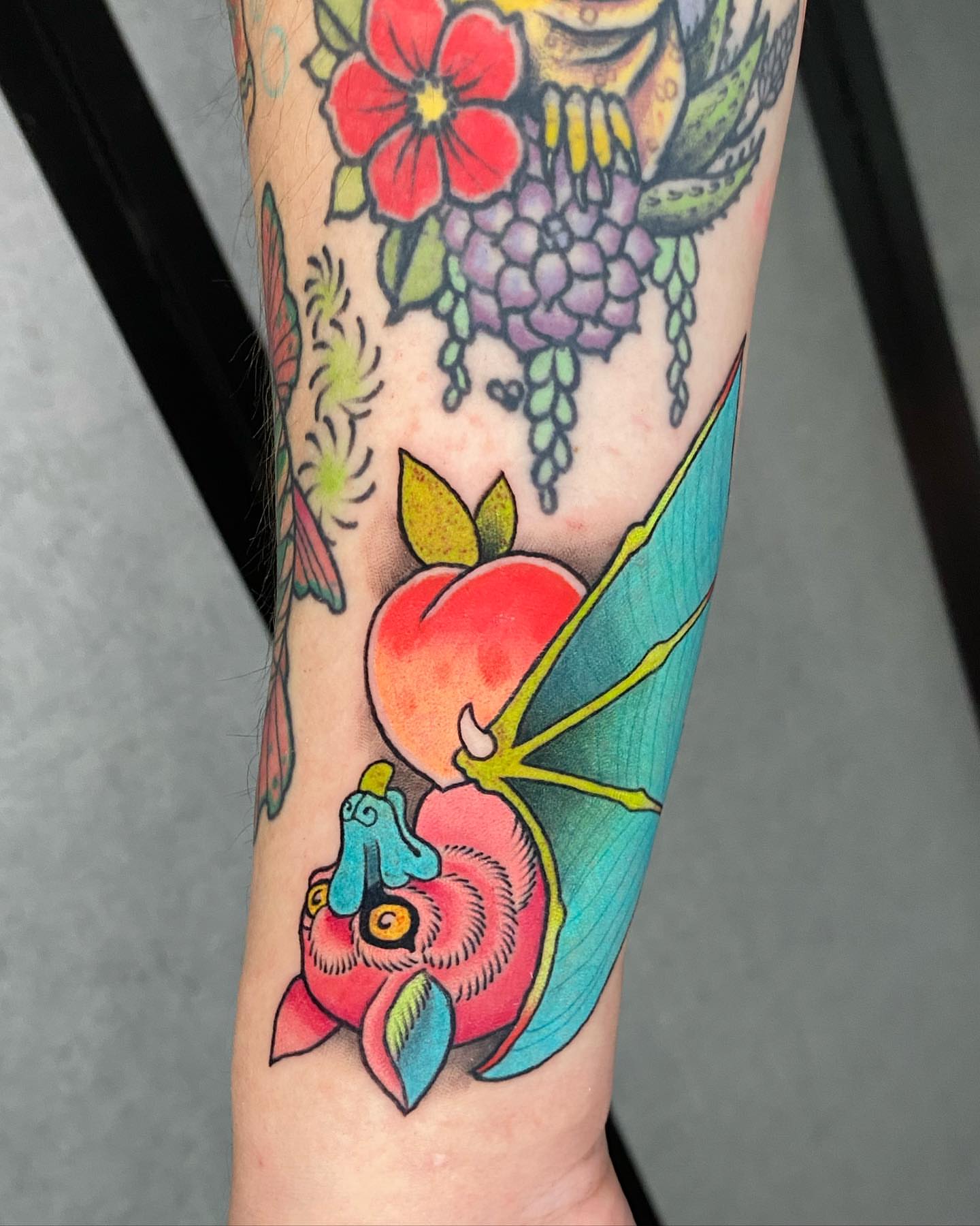 Peach and flower American traditional tattoo on the forearm by Mitch Bonifay