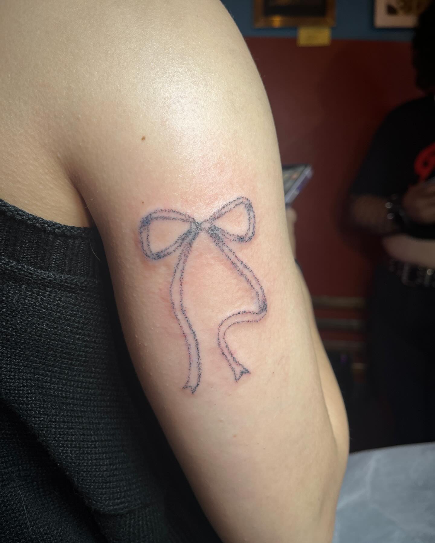 Bow fine line tattoo on the forearm by hana