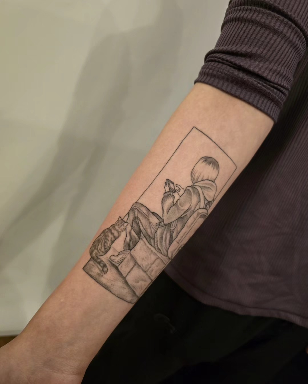 Child reading black and grey tattoo on the forearm by Lynx, Cincinnati, Ohio