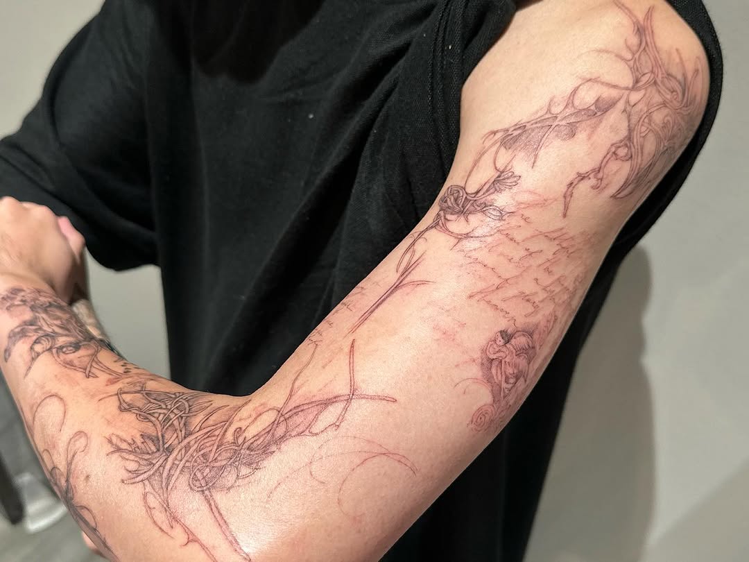 Ornamental script and floral elements cyber sigilism tattoo on the forearm by @taravychi