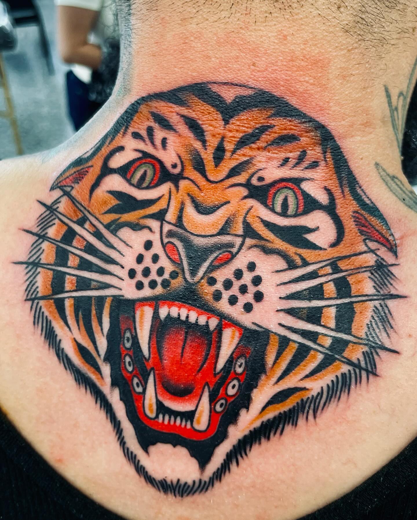Tiger head American traditional tattoo on the neck by Dave G