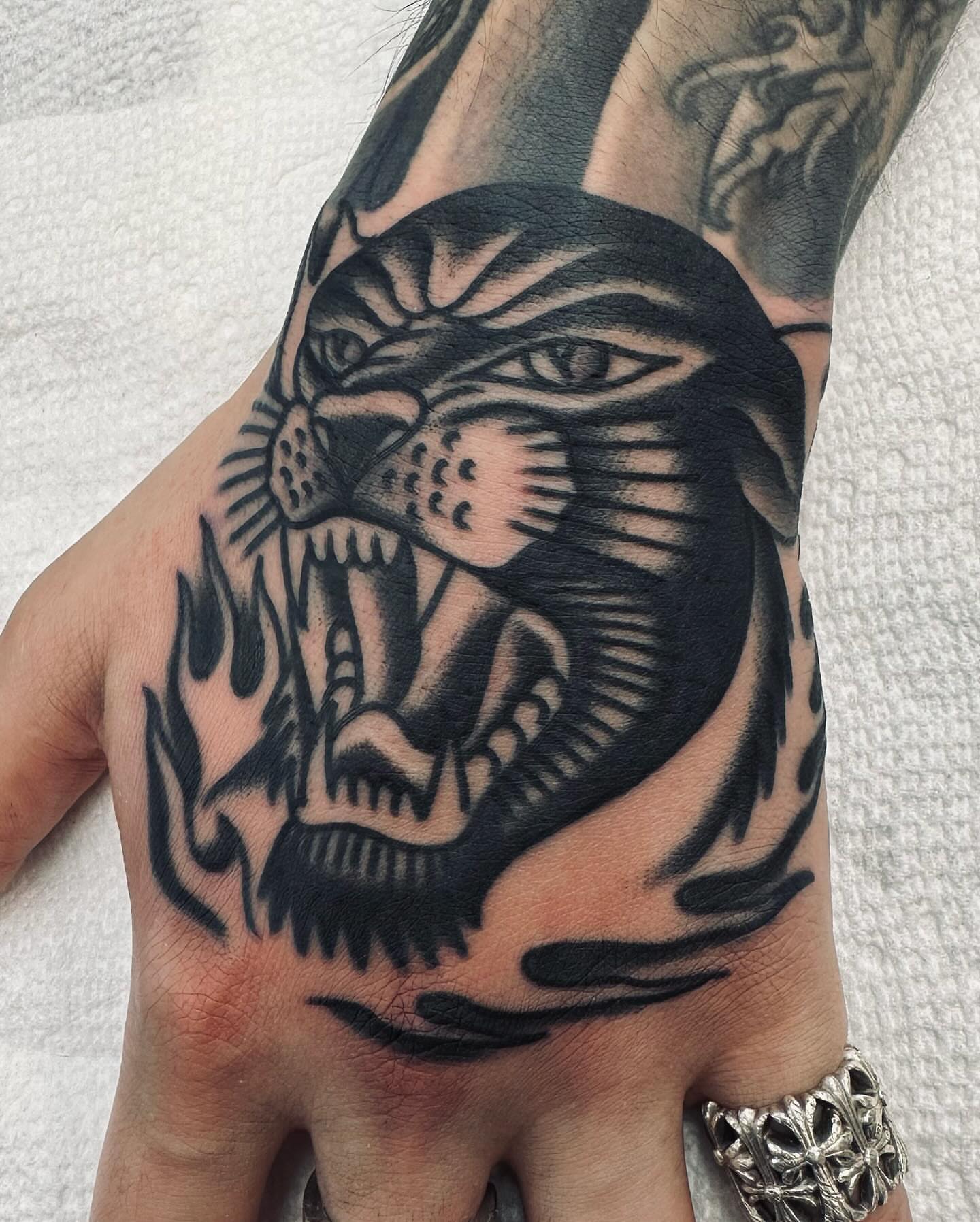 Panther black and grey tattoo on the hand by Dave G
