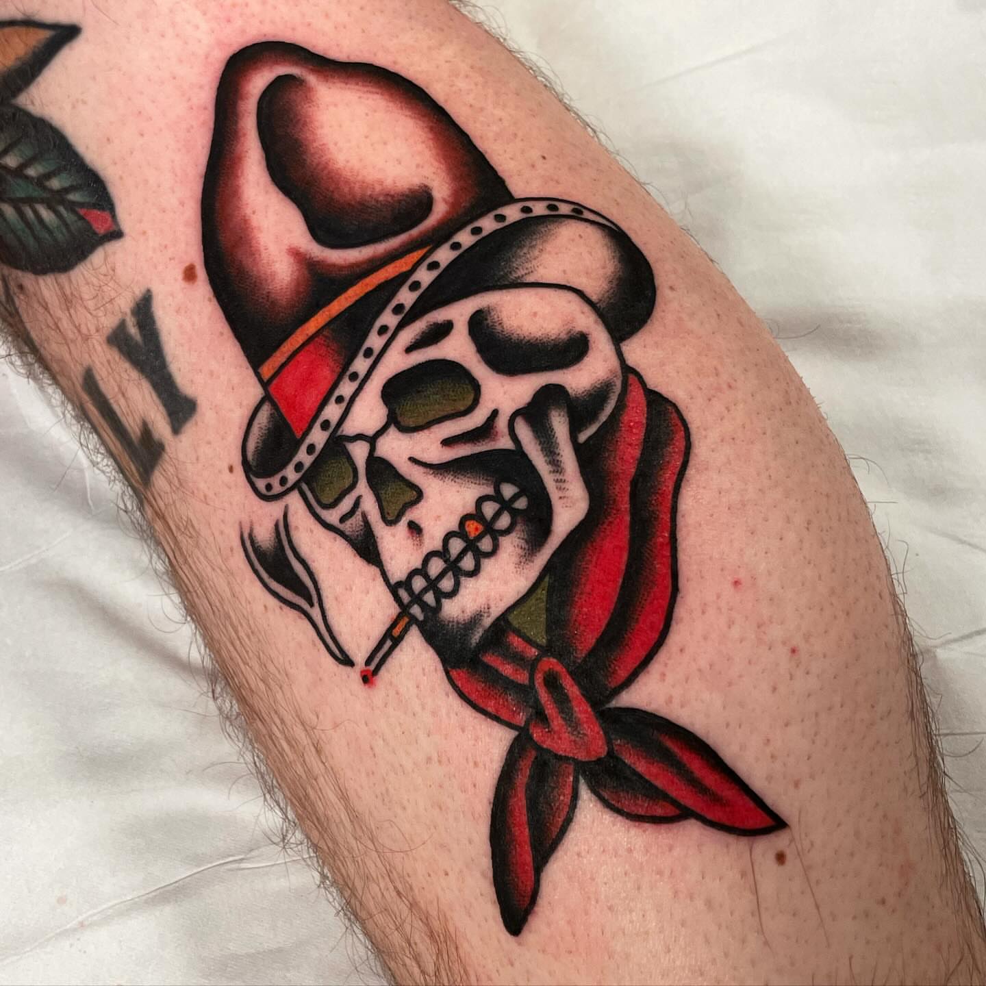 Smoking skull with bandana American traditional tattoo on the forearm by Mike Hudgins