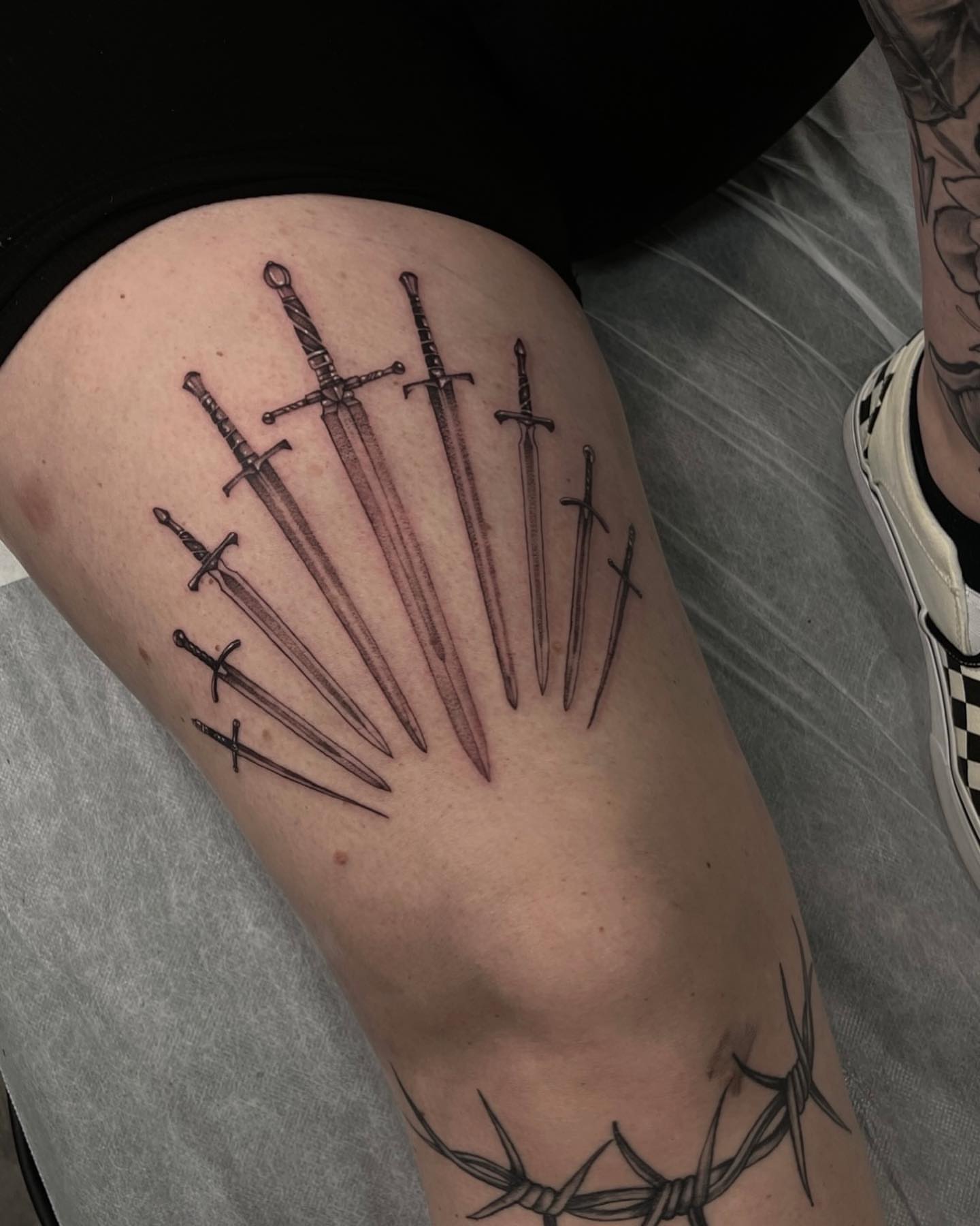 Swords black and grey tattoo on the thigh by Morrison Vo