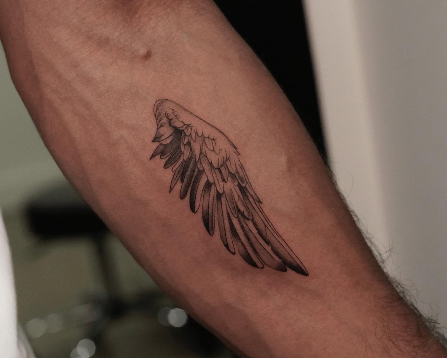 Wing black and grey tattoo on the forearm by eddie chavez