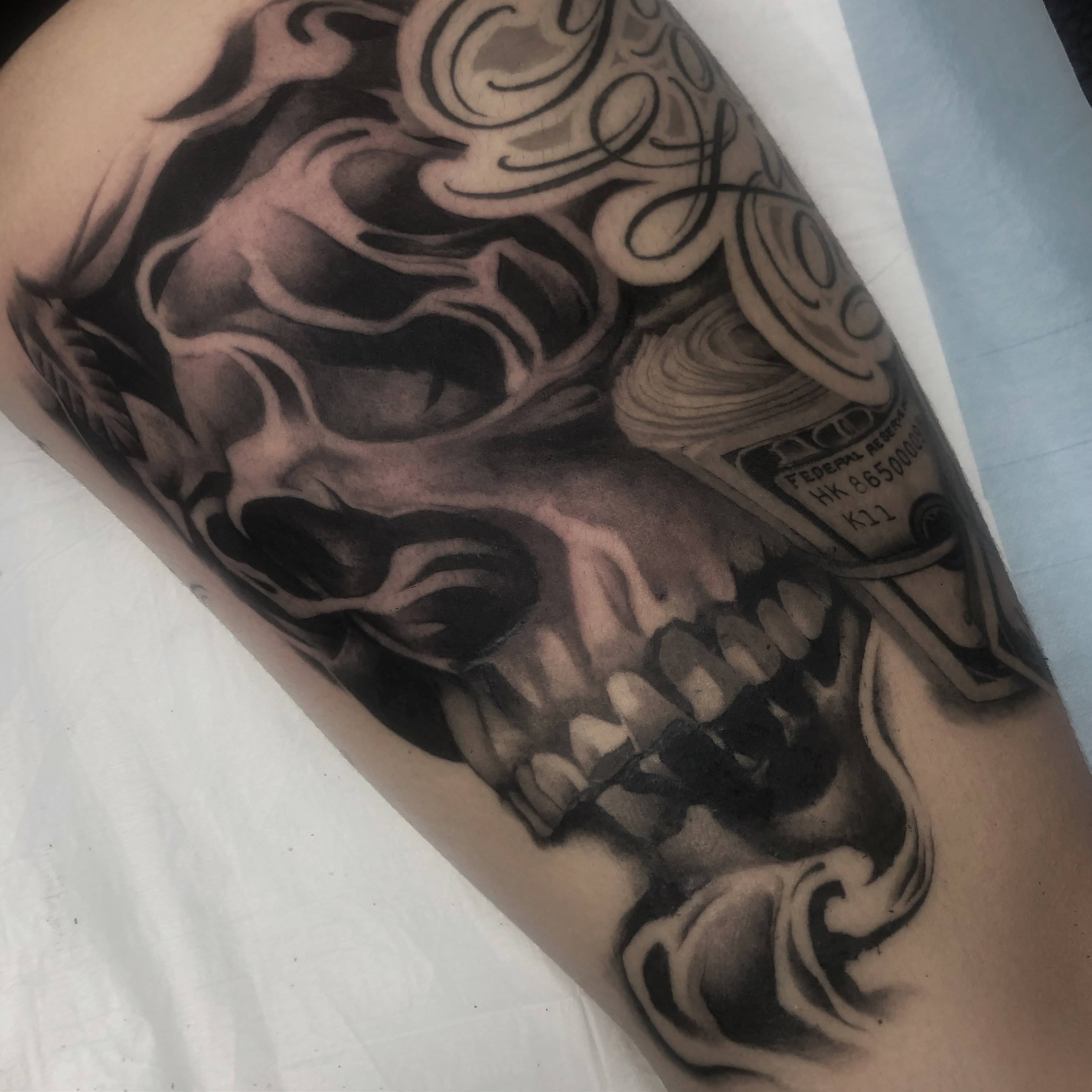 Grinning skull realism tattoo on the forearm by Chicanocustomlettering