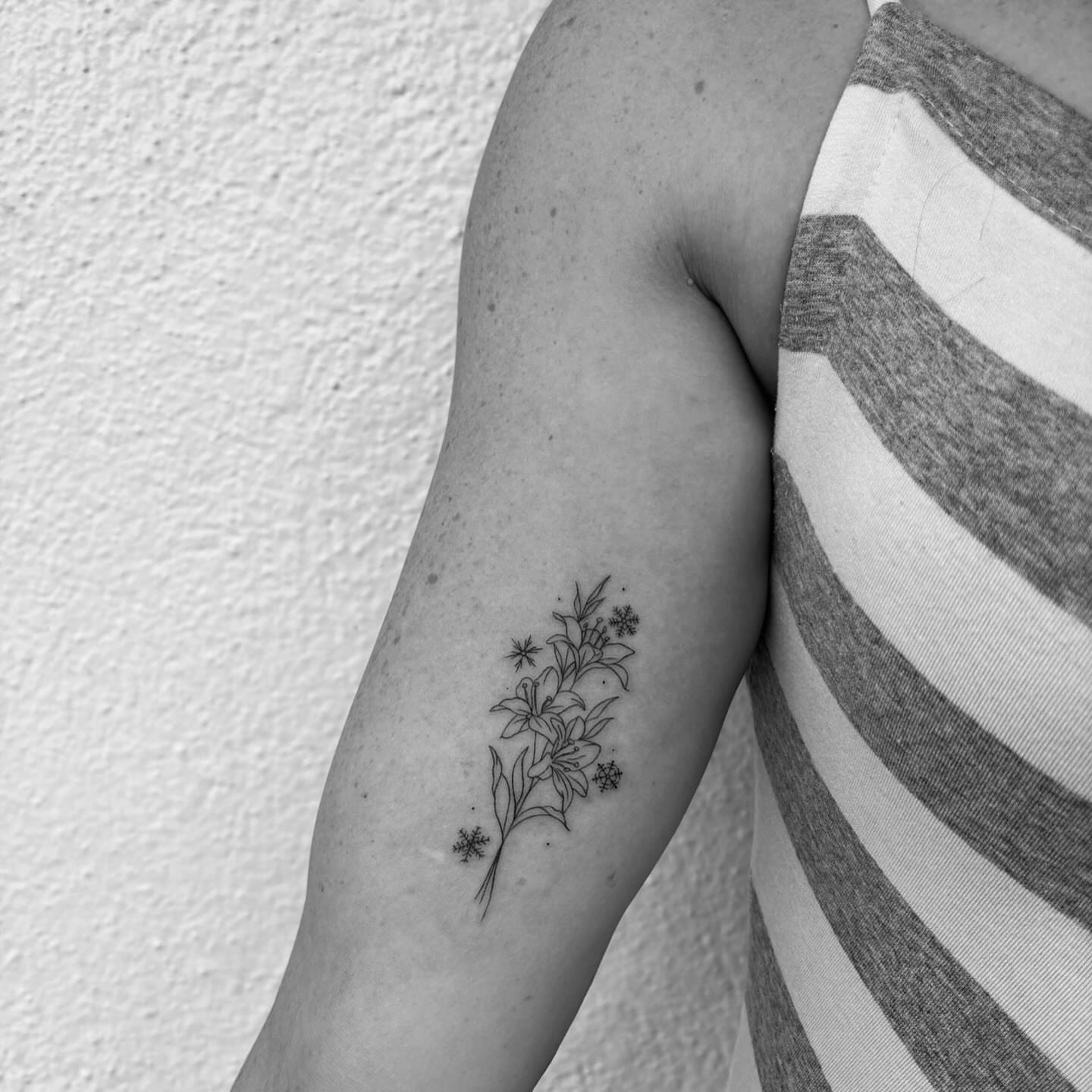 Floral arrangement fine line tattoo on the forearm by Mady