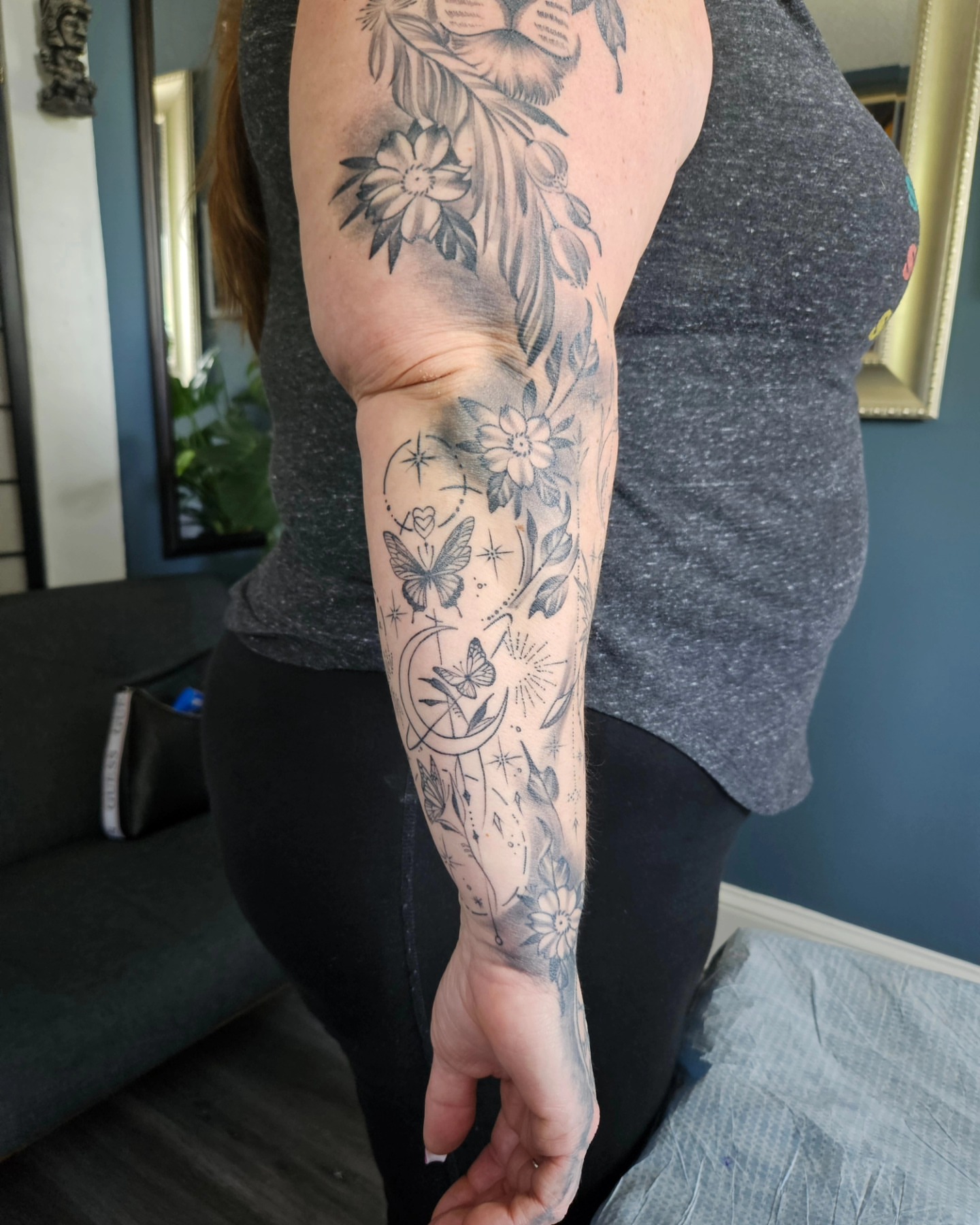Floral and butterfly black and grey tattoo on the forearm by German Romero-Rendon