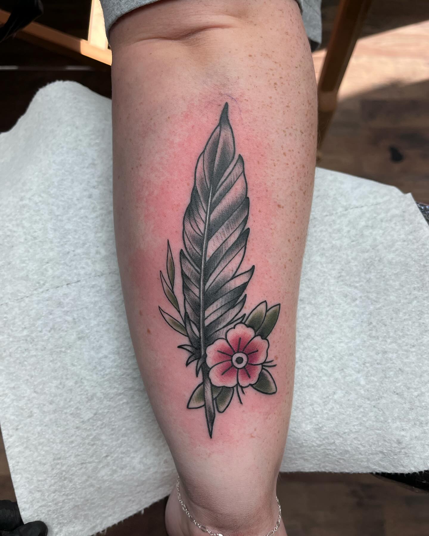 Feather and flower black and grey tattoo on the calf by Waylen Foster