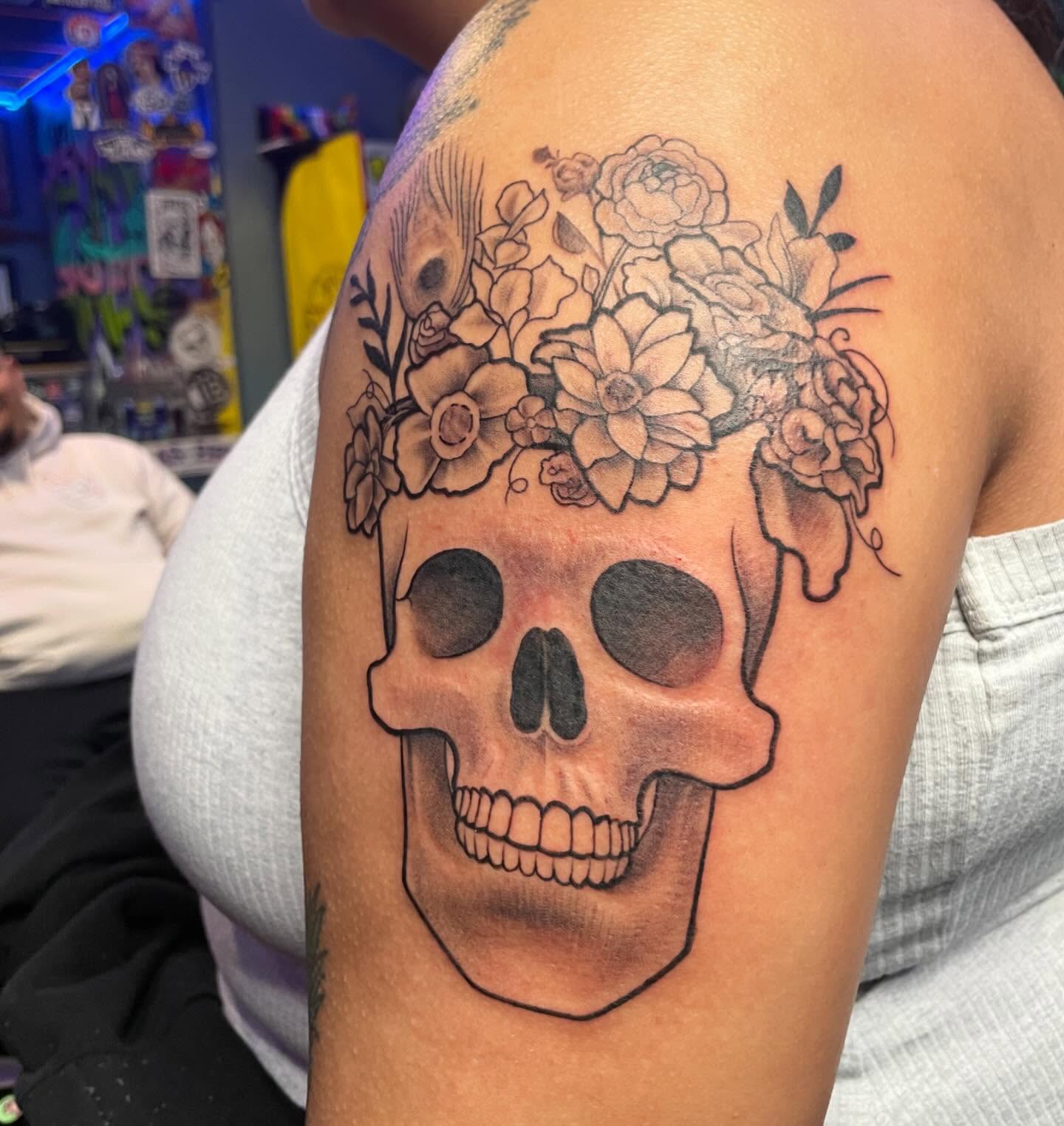Skull with floral crown realism tattoo on the shoulder by Abel Ponce
