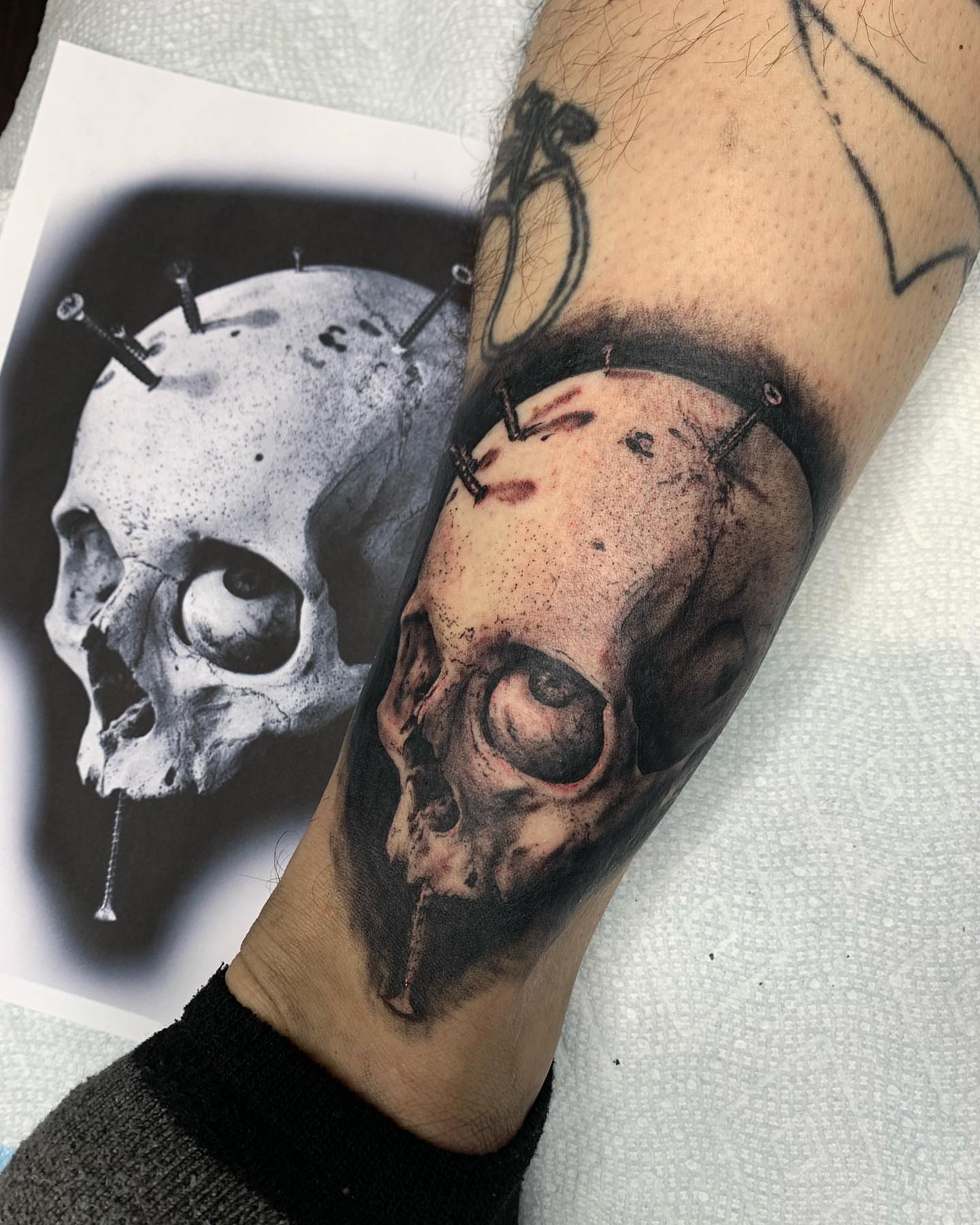 Skull with nails dark realism tattoo on the forearm by Rory Somerville