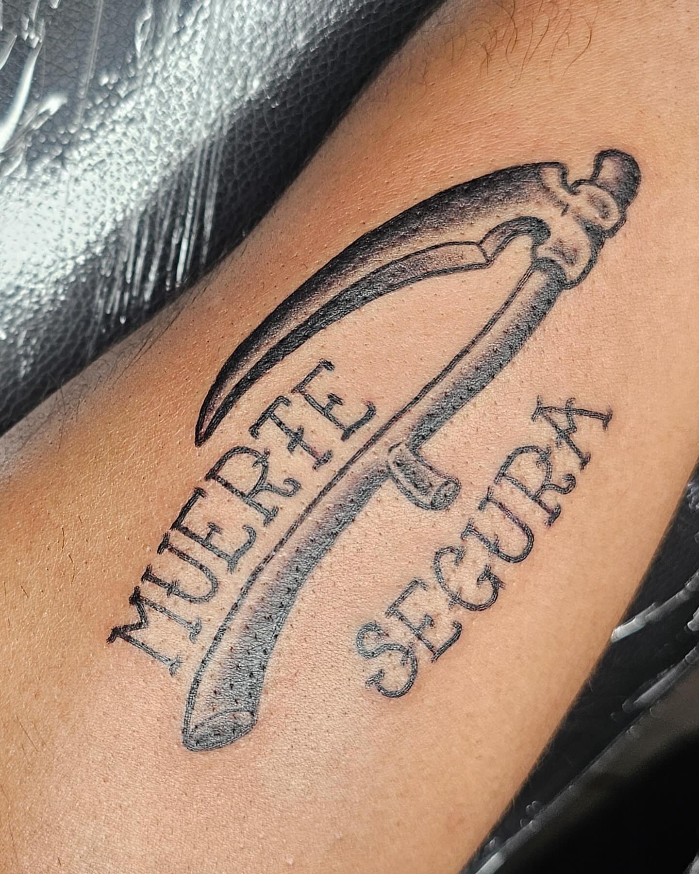 Knife and text black and grey tattoo on the forearm by J. Arturo Laparra
