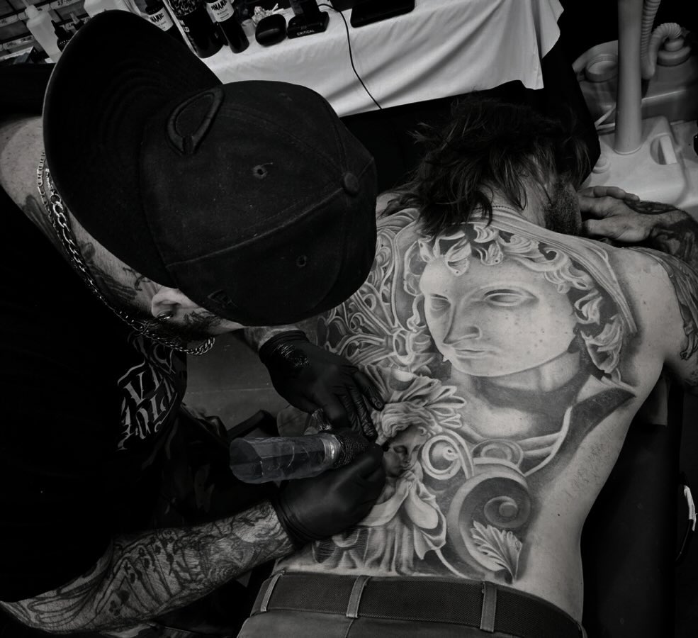 Statue black and grey tattoo on the chest by Brian Keith