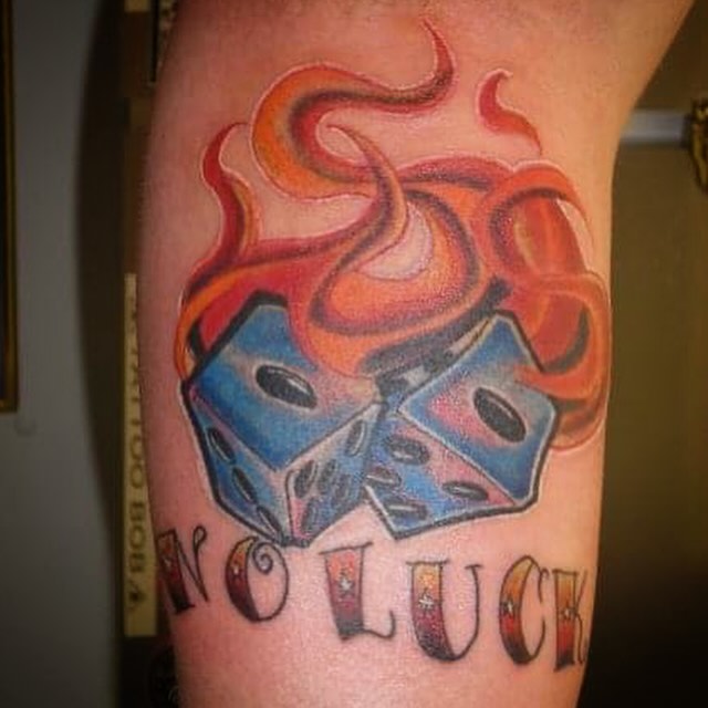 Flaming dice realism tattoo on the forearm by Bobby Glennon