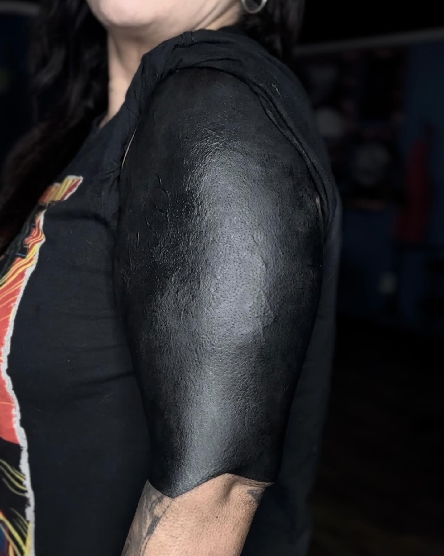 Blackout blackwork tattoo on the upper arm by Emersyn DeLuna