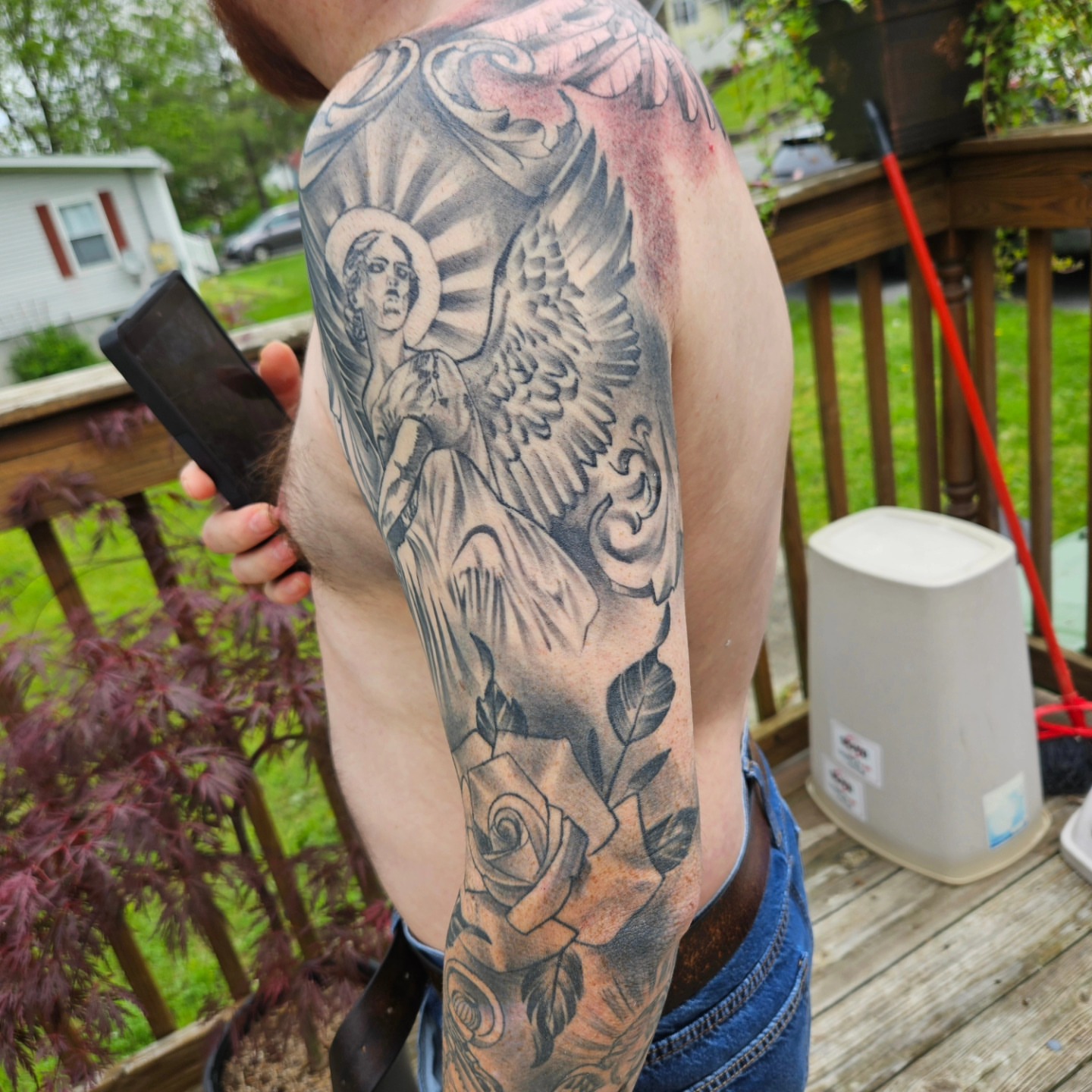 Angel with halo black and grey tattoo on the upper arm by German Romero-Rendon