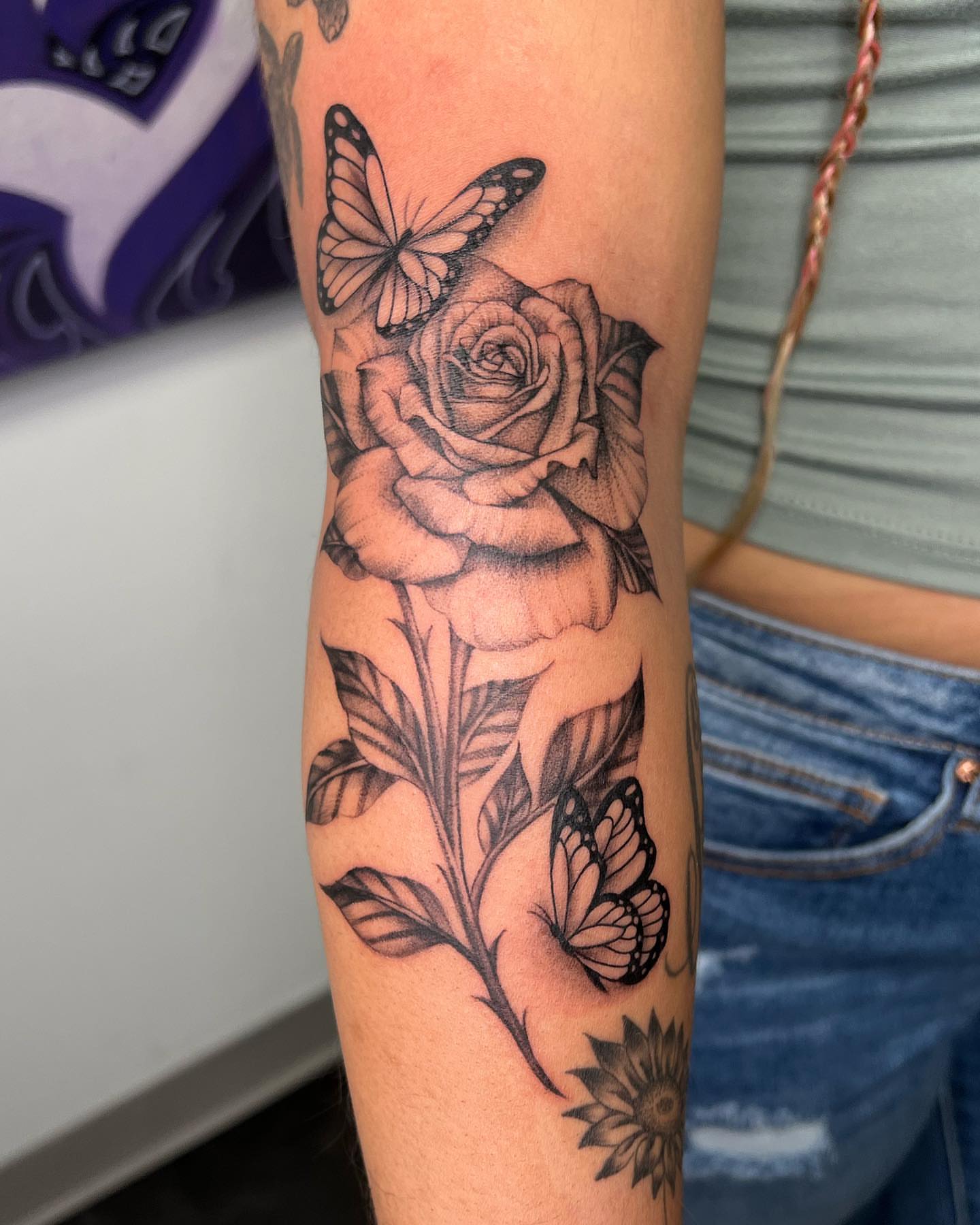Rose and butterflies realism tattoo on the forearm by San Diego Fineline Black & Grey Tattoo Artist