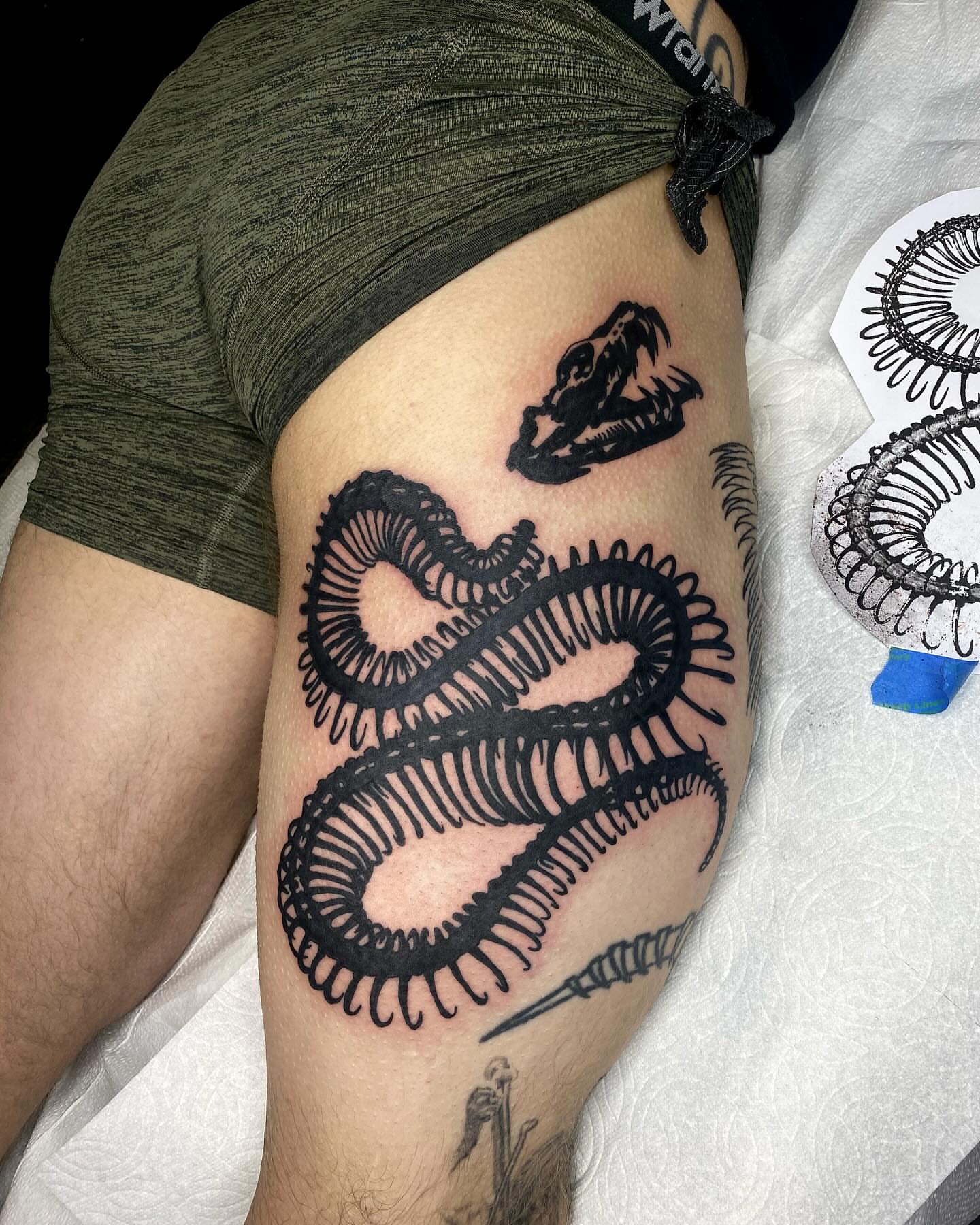 Snake black and grey tattoo on the thigh by Hayden Earley