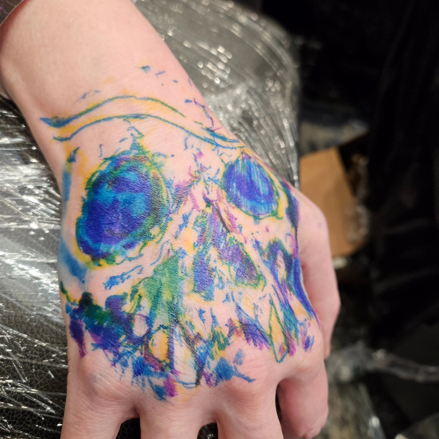 Watercolor skull watercolor tattoo on the hand by Chicagoland Tattoo artist - Dany Rojas