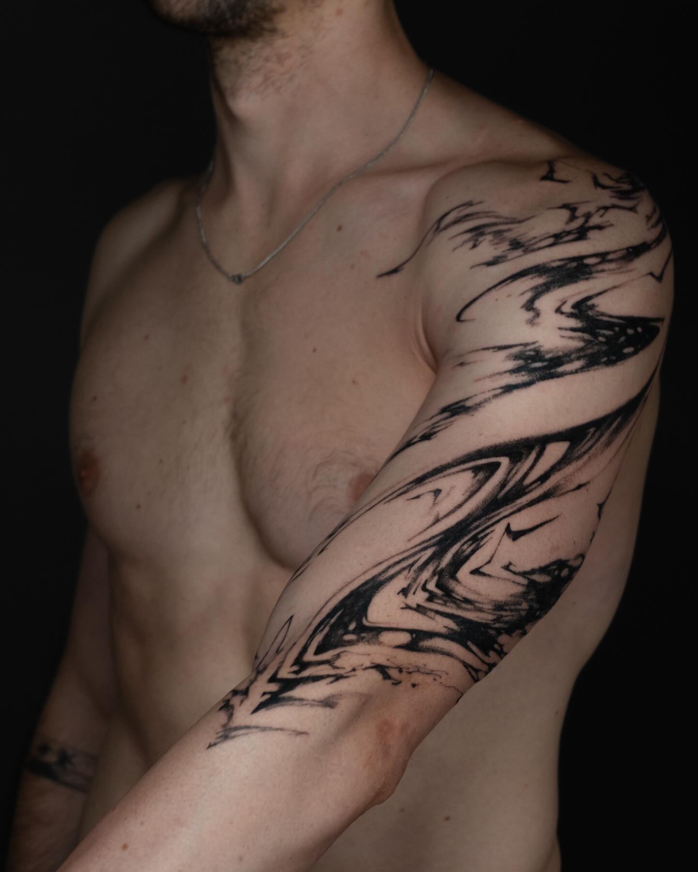 Abstract swirl black and grey tattoo on the upper arm by Pietro Moleti