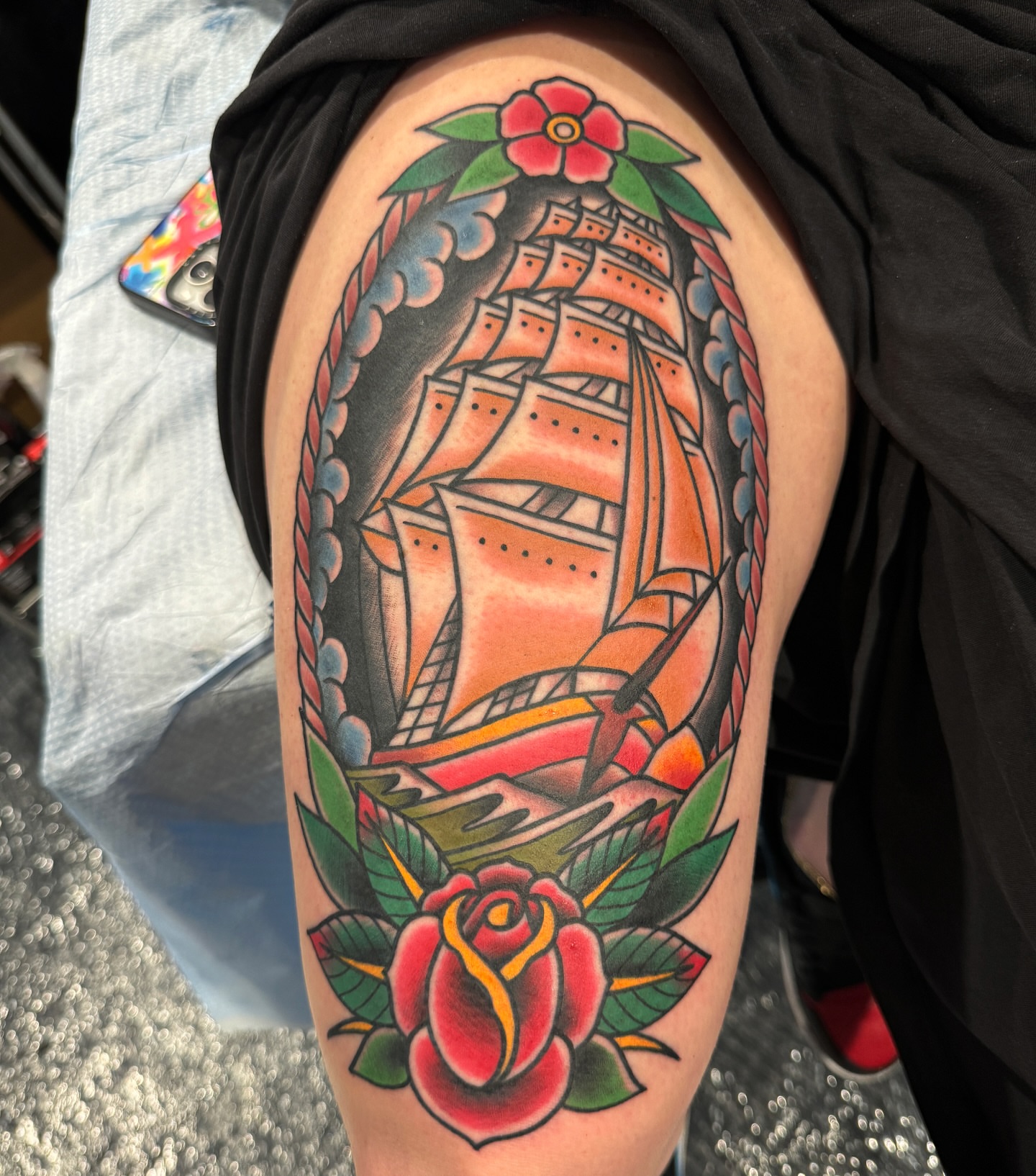 Ship and rose American traditional tattoo on the upper arm by Donovan hernandez