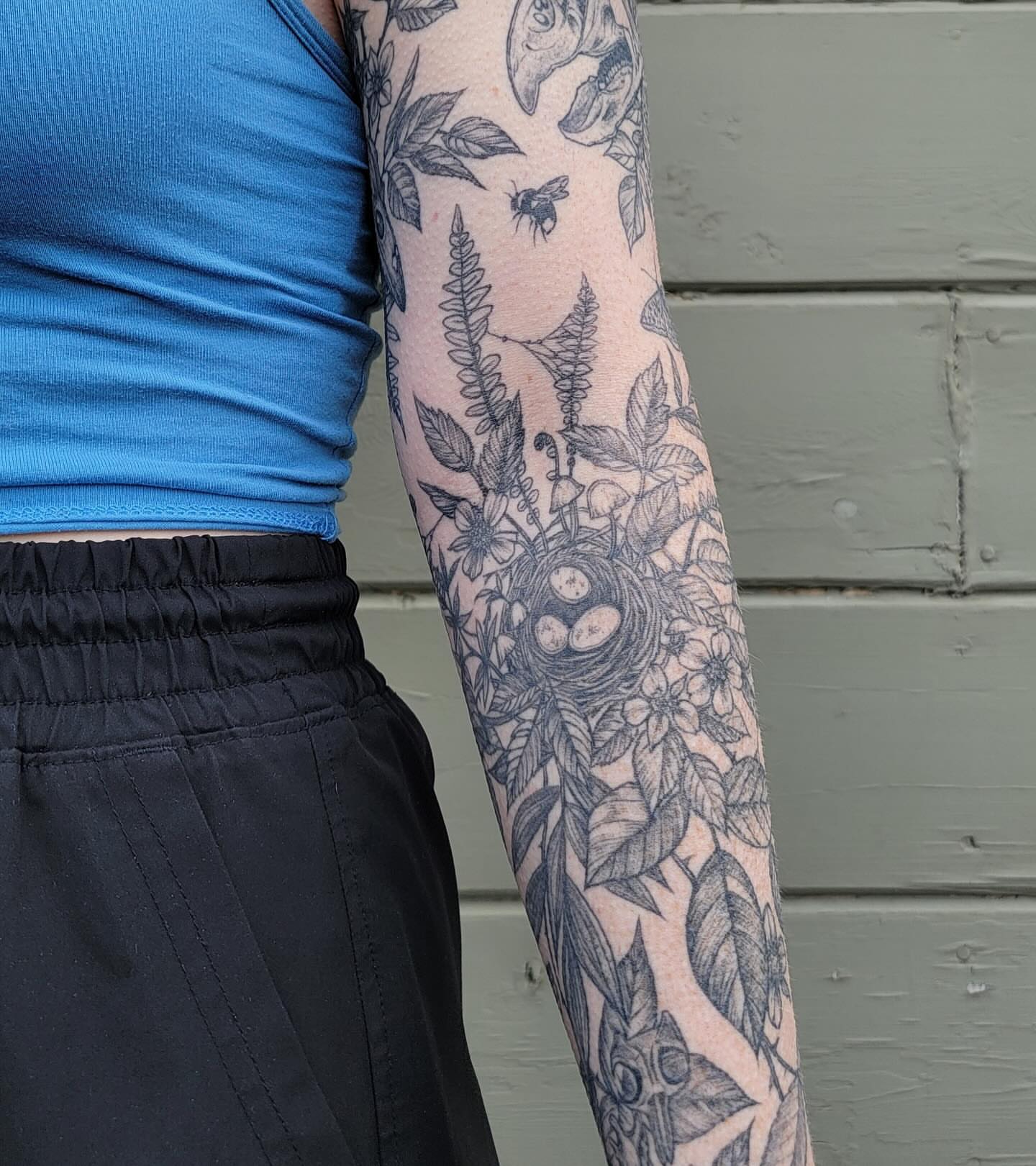 Botanical and bird black and grey tattoo on the forearm by Sierra (cc) Klein