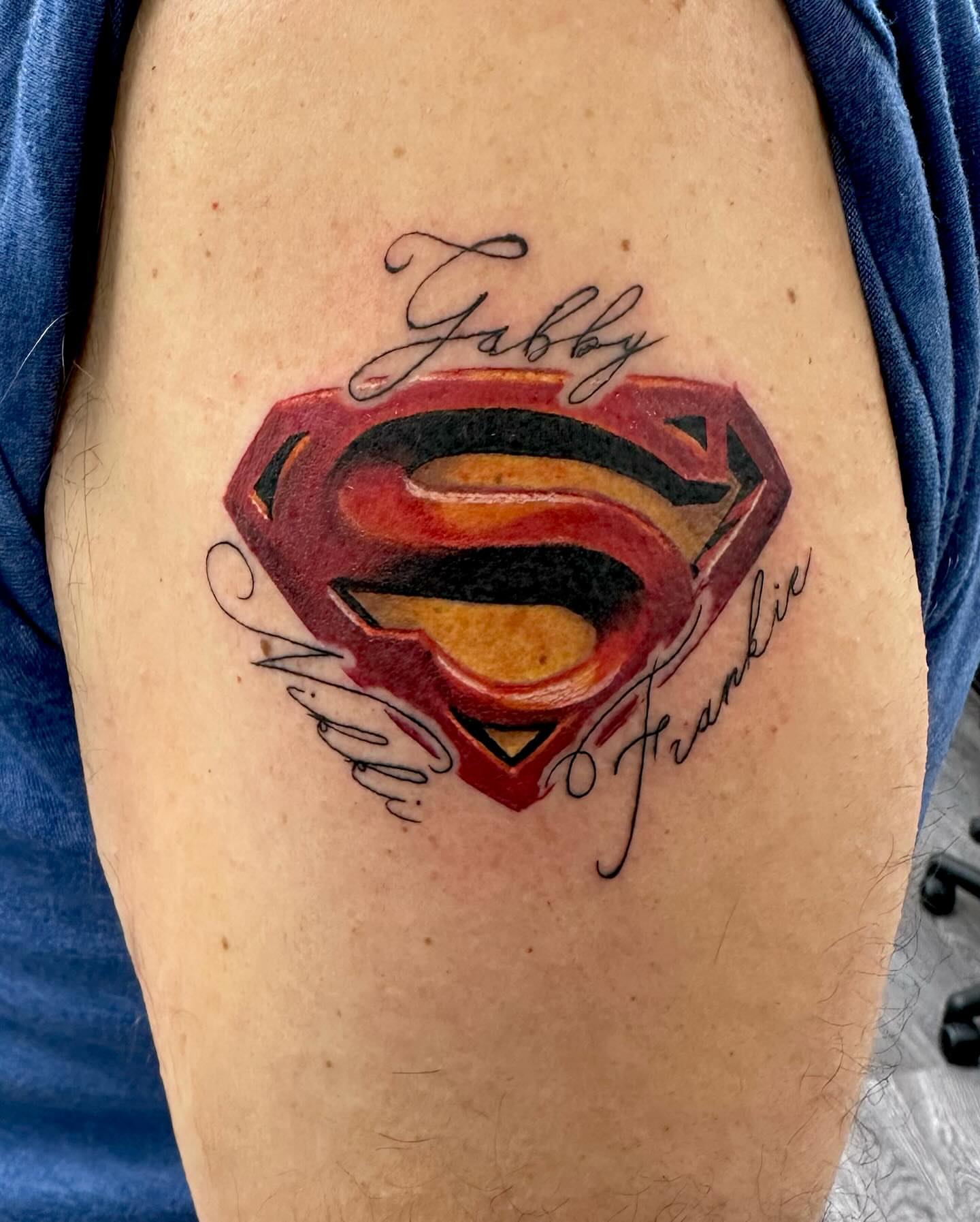 Superman logo American traditional tattoo on the upper arm by MR