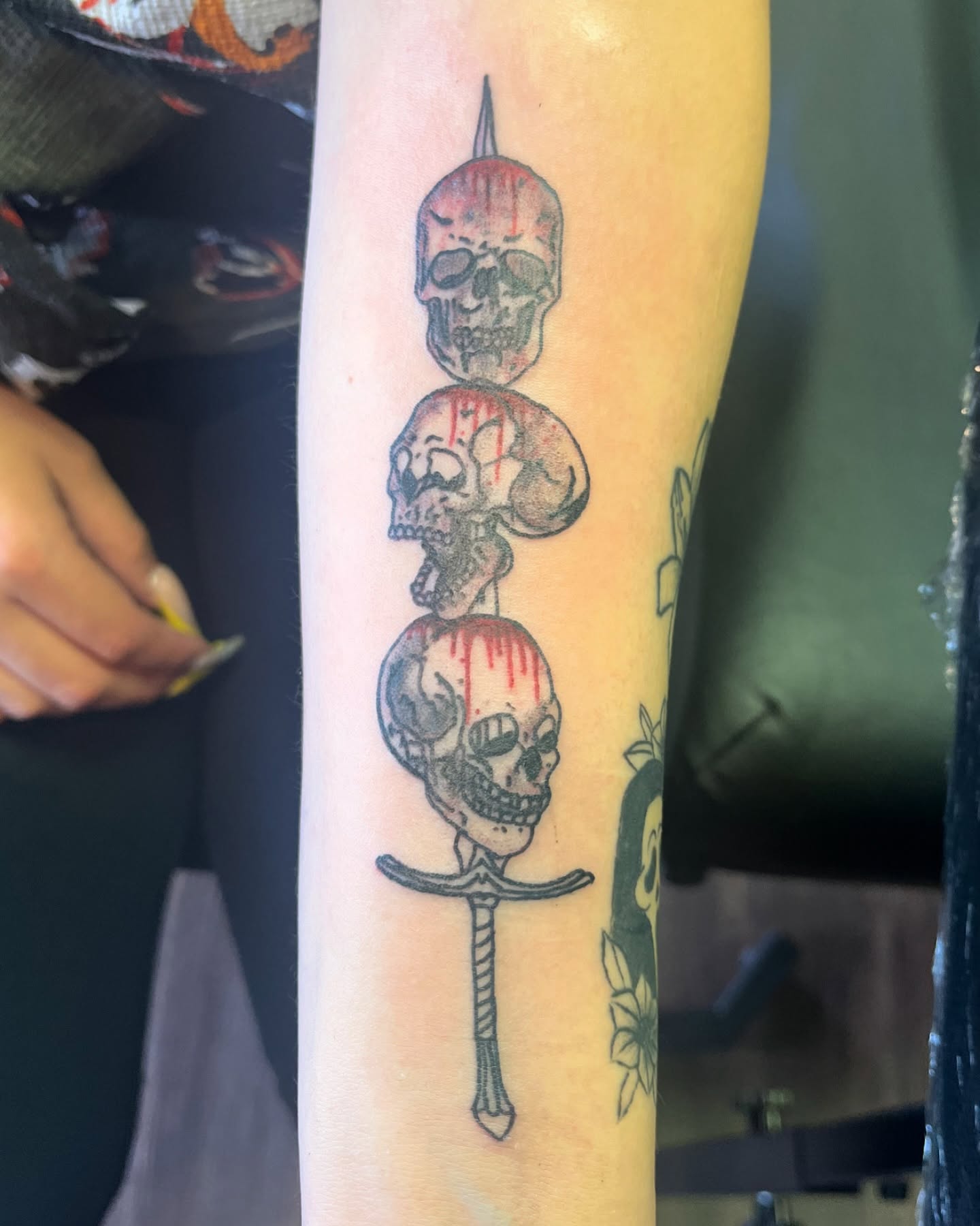 Skulls and dagger black and grey tattoo on the forearm by Michelle