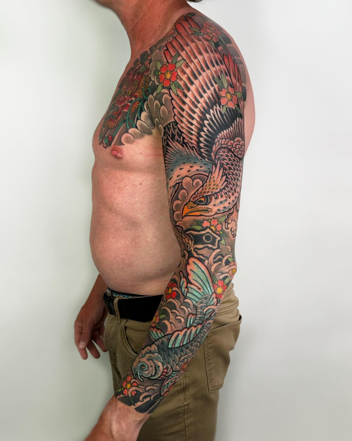 Bird and floral American traditional tattoo on the upper arm by Forrest Henderson 森
