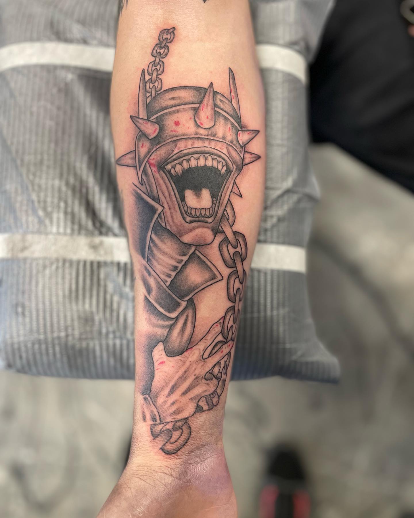 Demon helmet black and grey tattoo on the forearm by Brandon Anderson