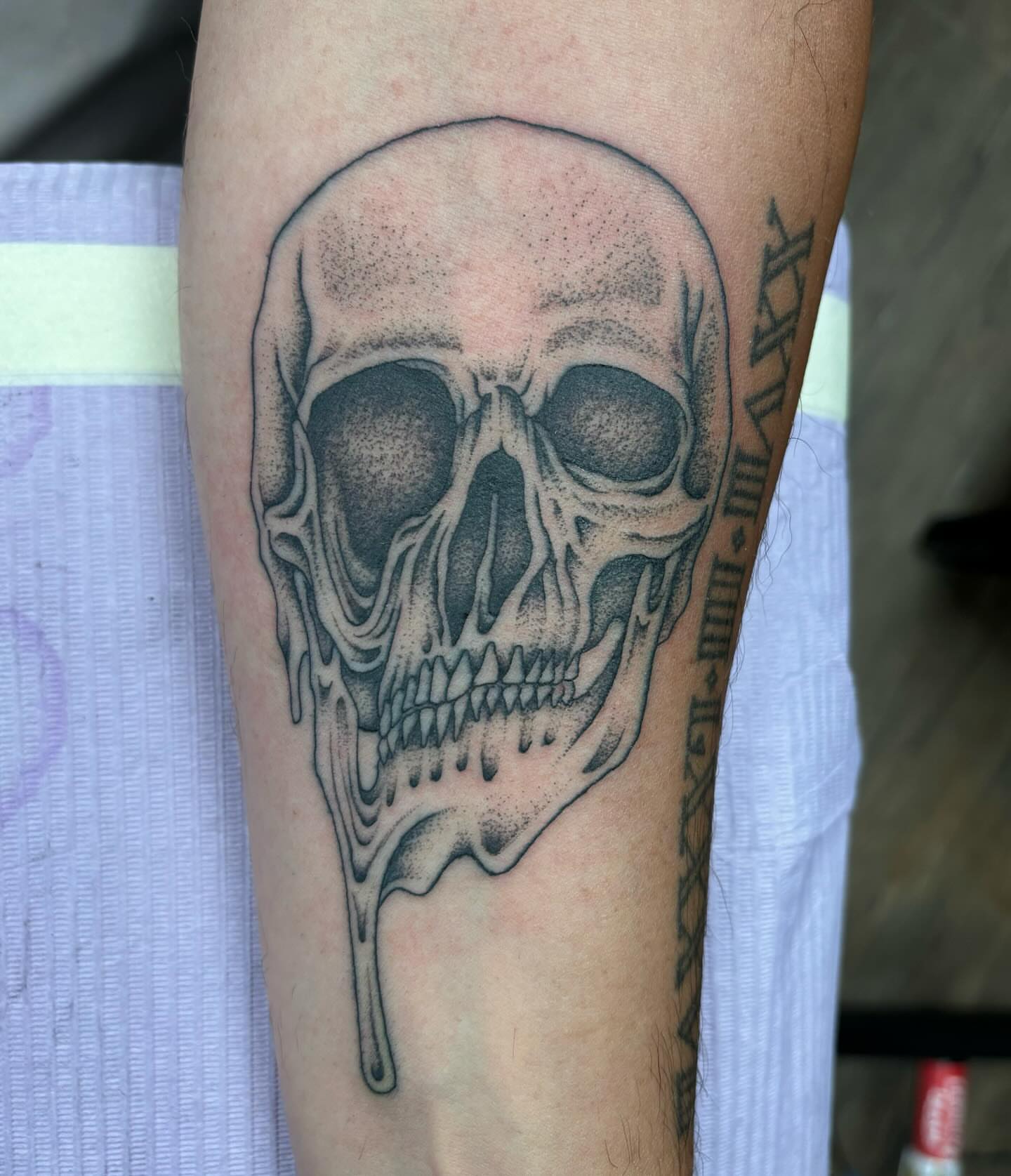Melting skull dotwork tattoo on the forearm by Brayden P Tattoo