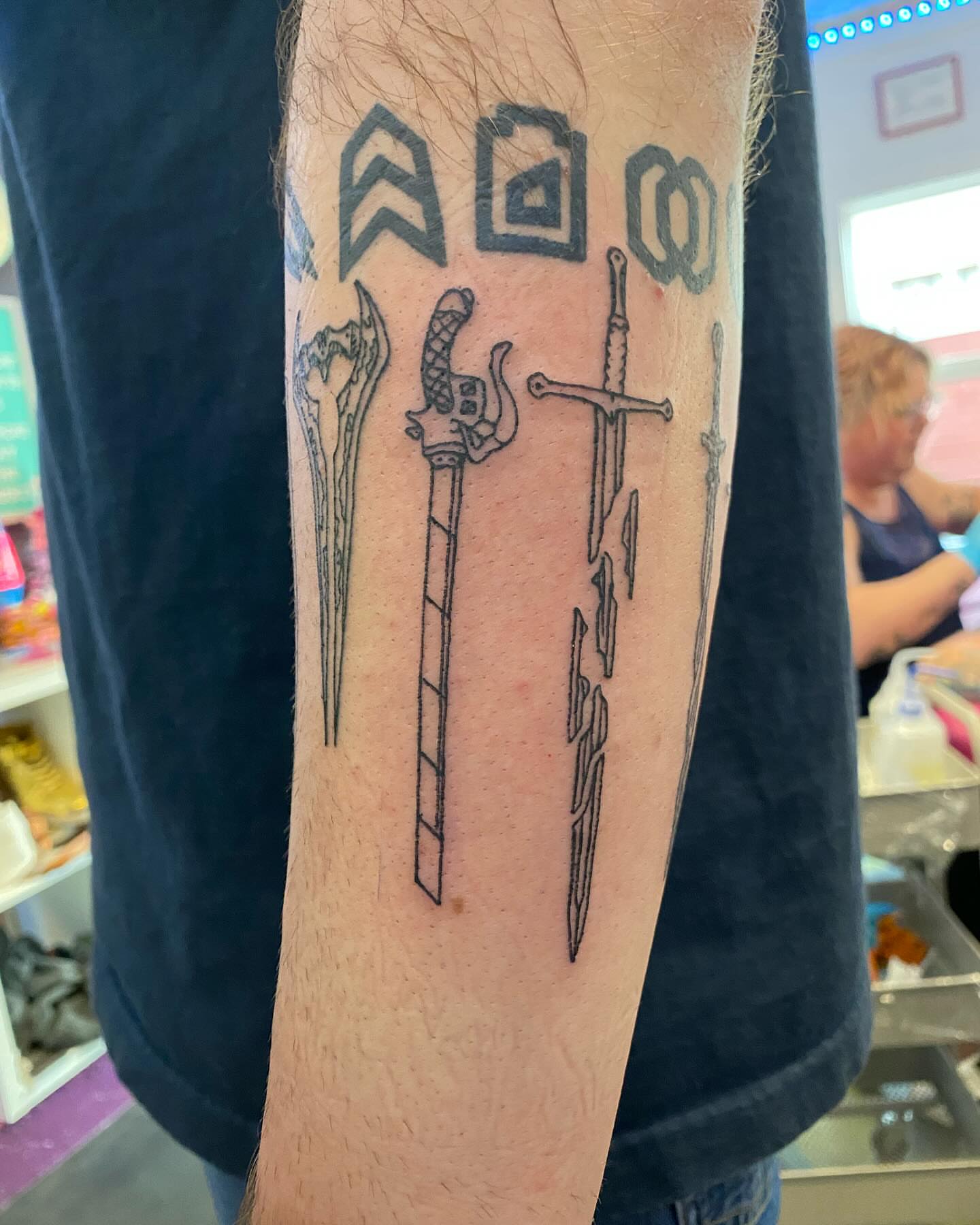 Sword and runes black and grey tattoo on the forearm by Tesla Kohl