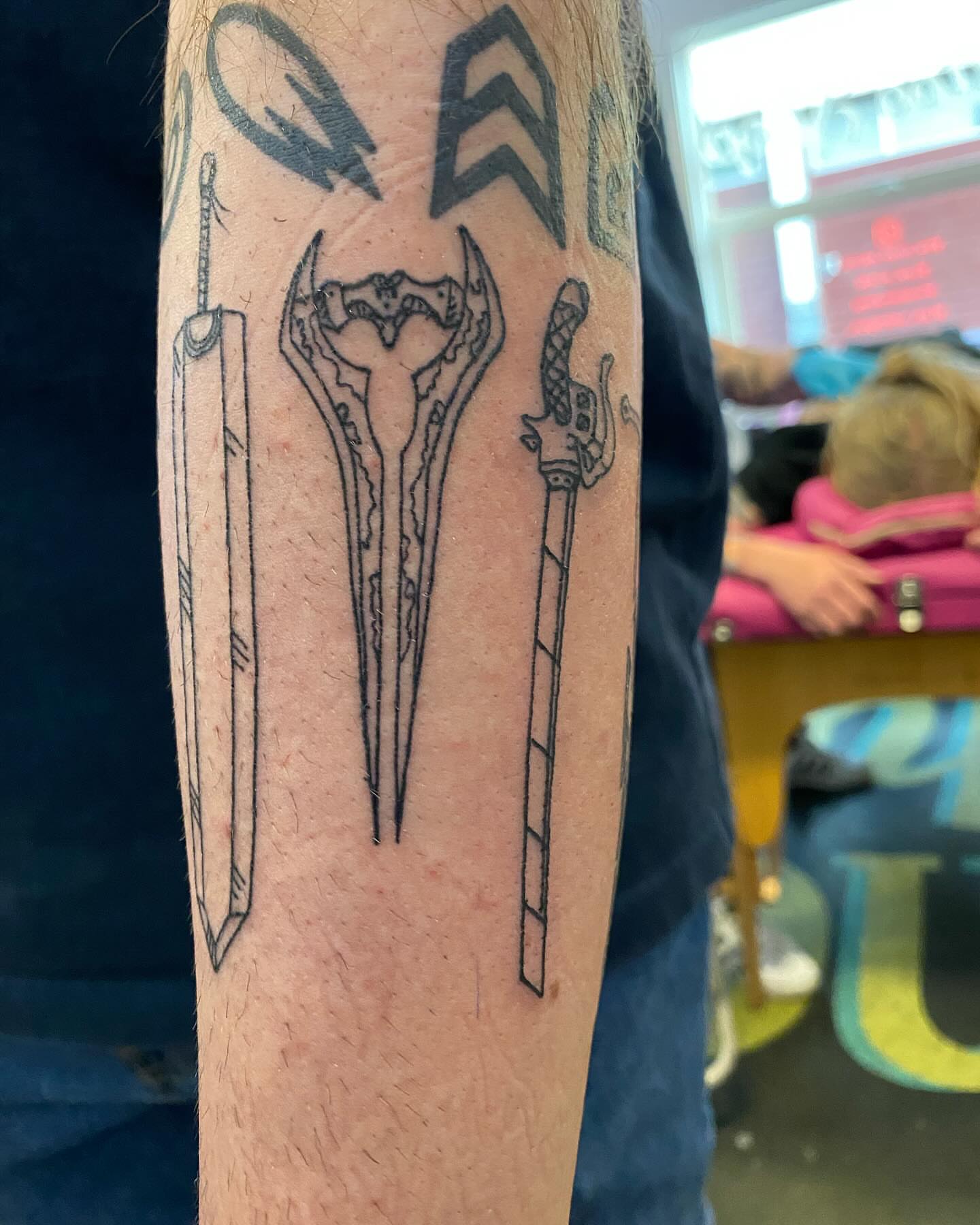 Swords and shield black and grey tattoo on the forearm by Tesla Kohl
