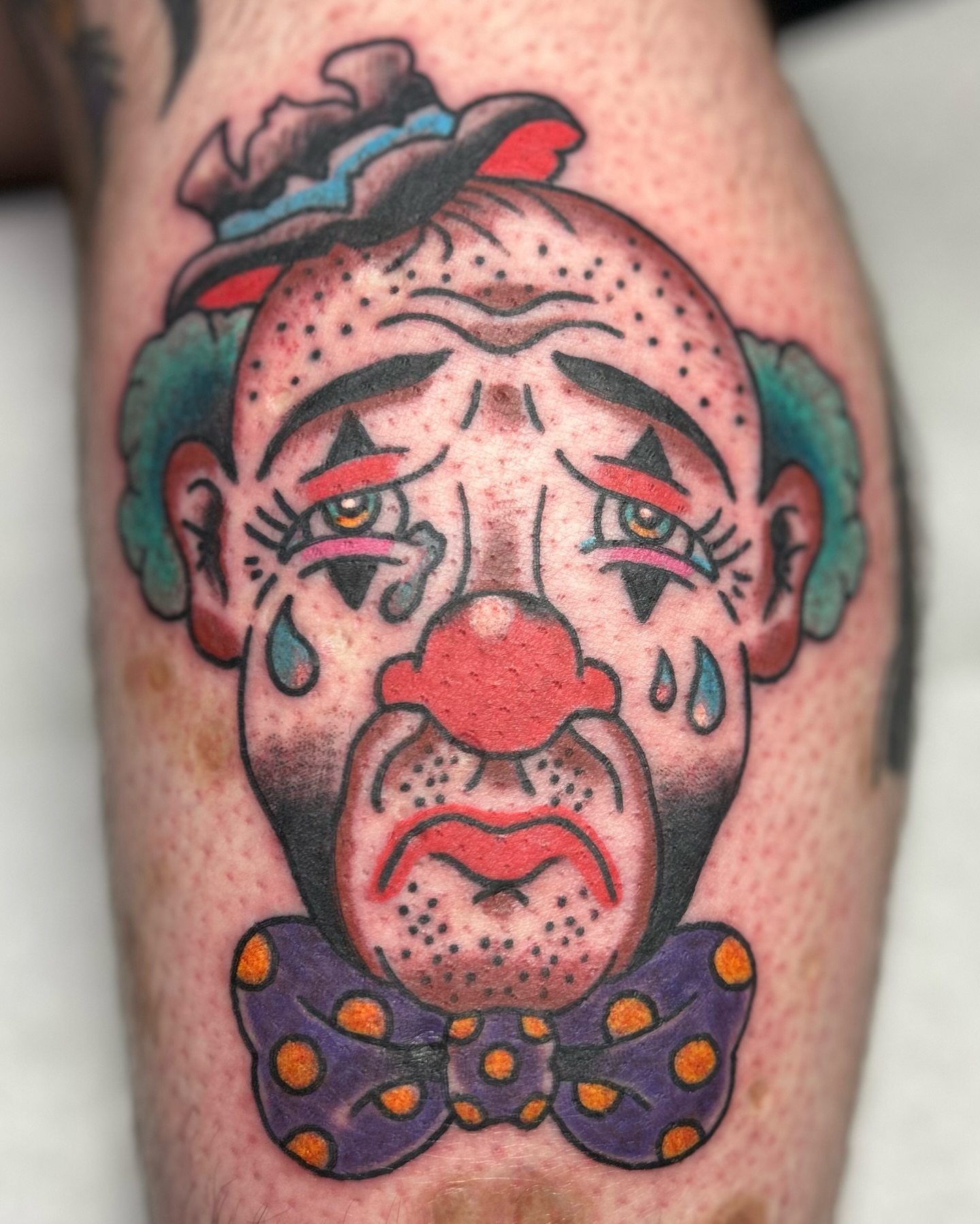 Sad clown American traditional tattoo on the forearm by Alex Fannin