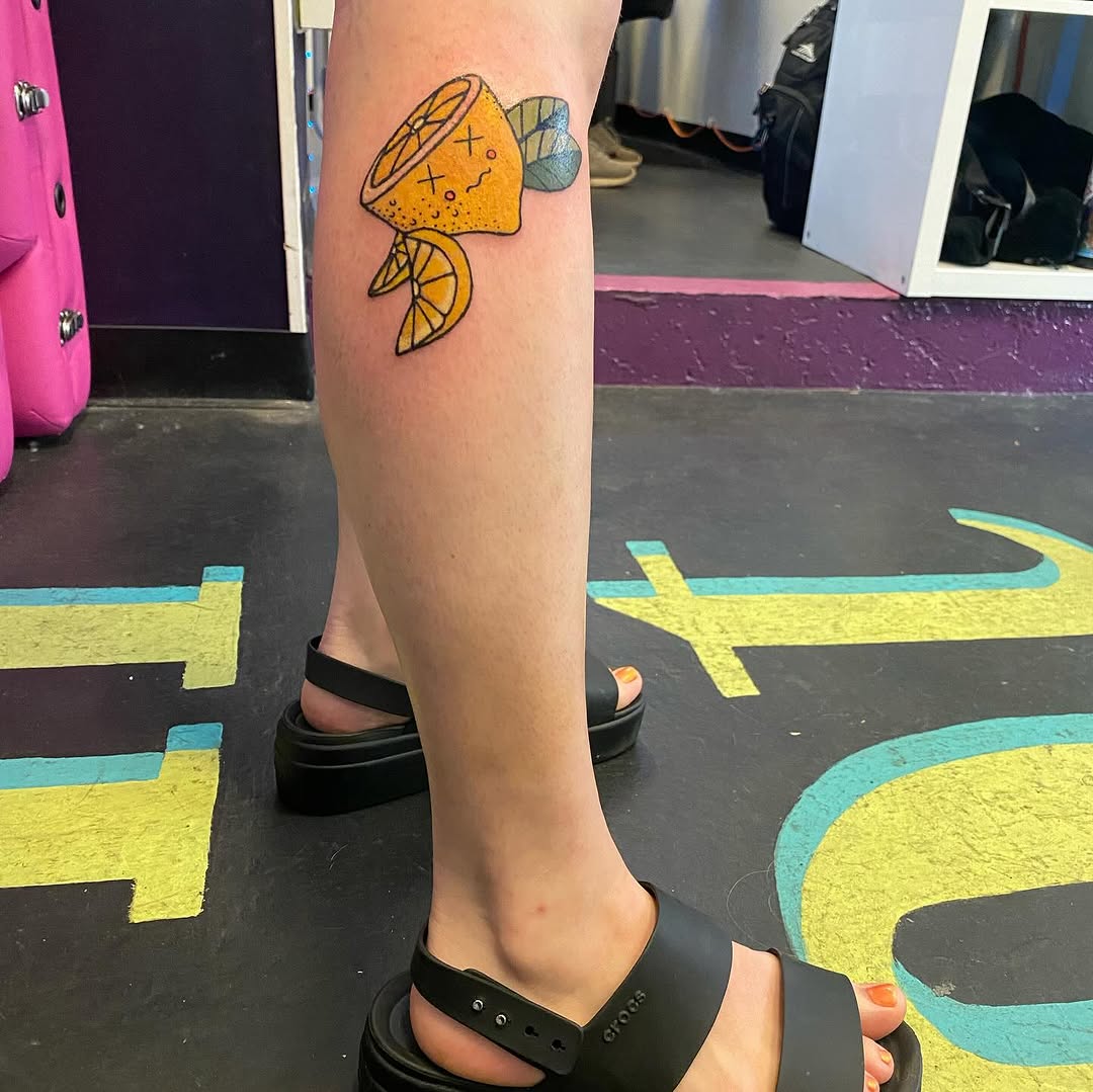 Cartoon lemon tattoo on the calf by Tesla Kohl