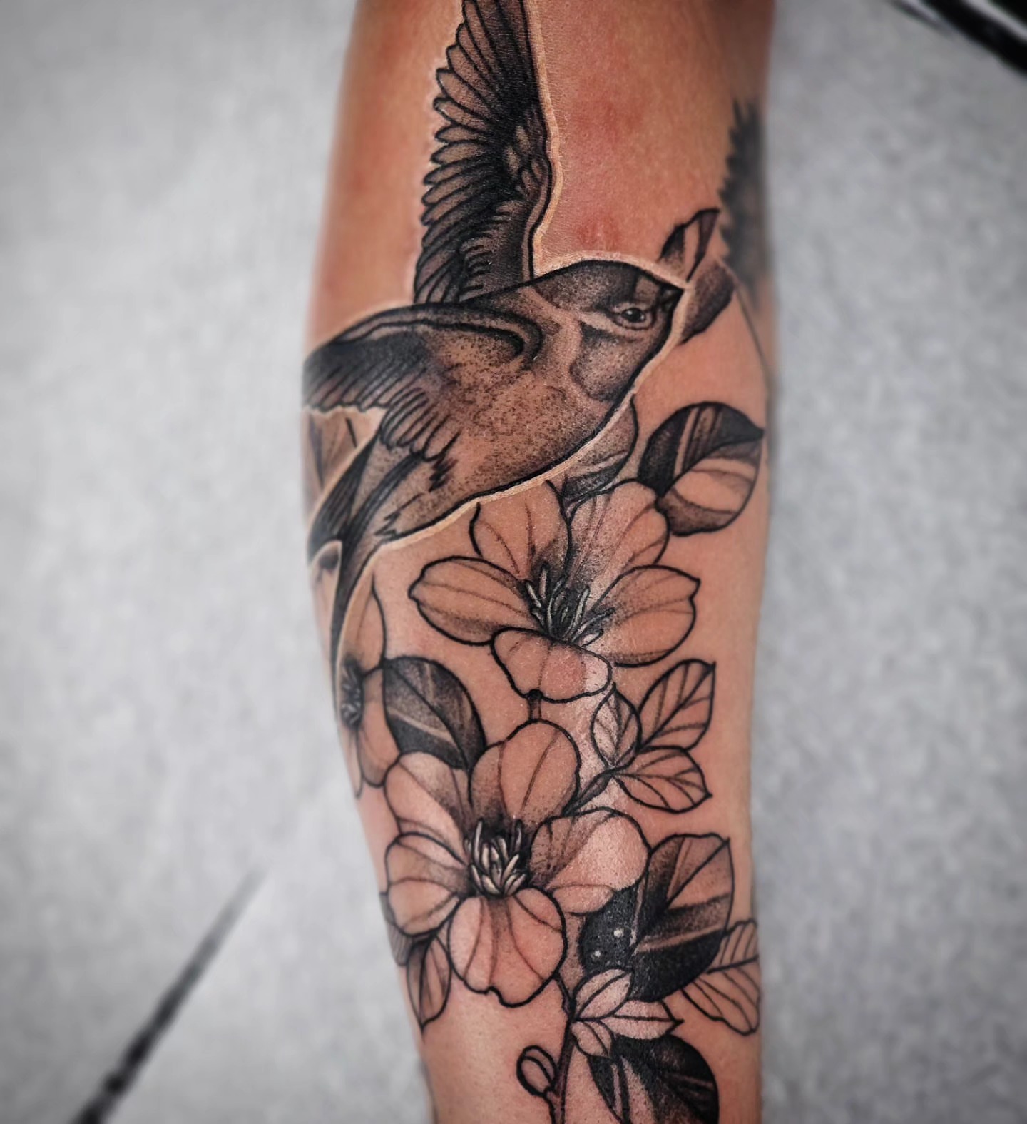Bird and flowers realism tattoo on the forearm by TattoosbyPhatboi