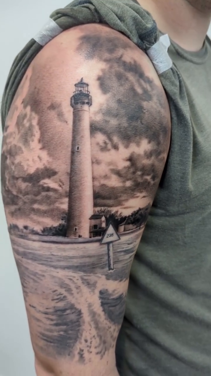 Lighthouse scene realism tattoo by Sean Costello