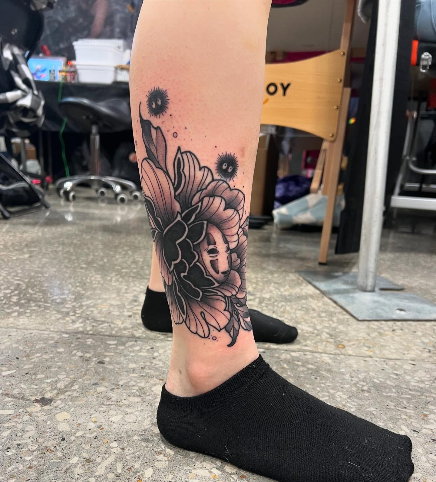Flower with mask dotwork tattoo on the calf by Brooke, Kansas City, Missouri